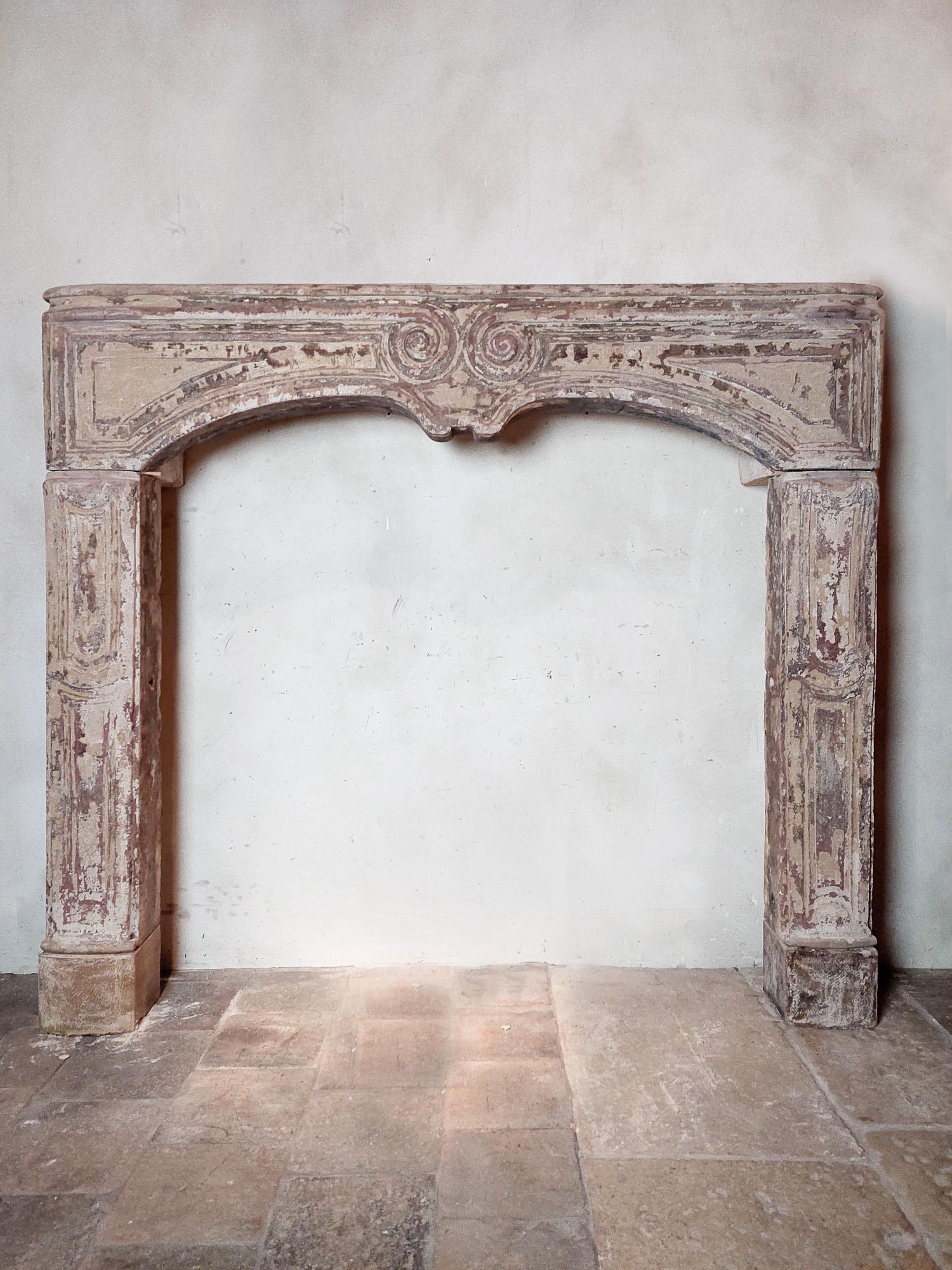 Antique sandstone Baroque mantelpiece from the 18th century. This large Louis XIV mantelpiece has beautiful patina remains in pink and beige powder color tones.

Dimensions: ± h 133 x w 149 x d 29 cm
inner dimensions: ± h 113 x 115 cm
