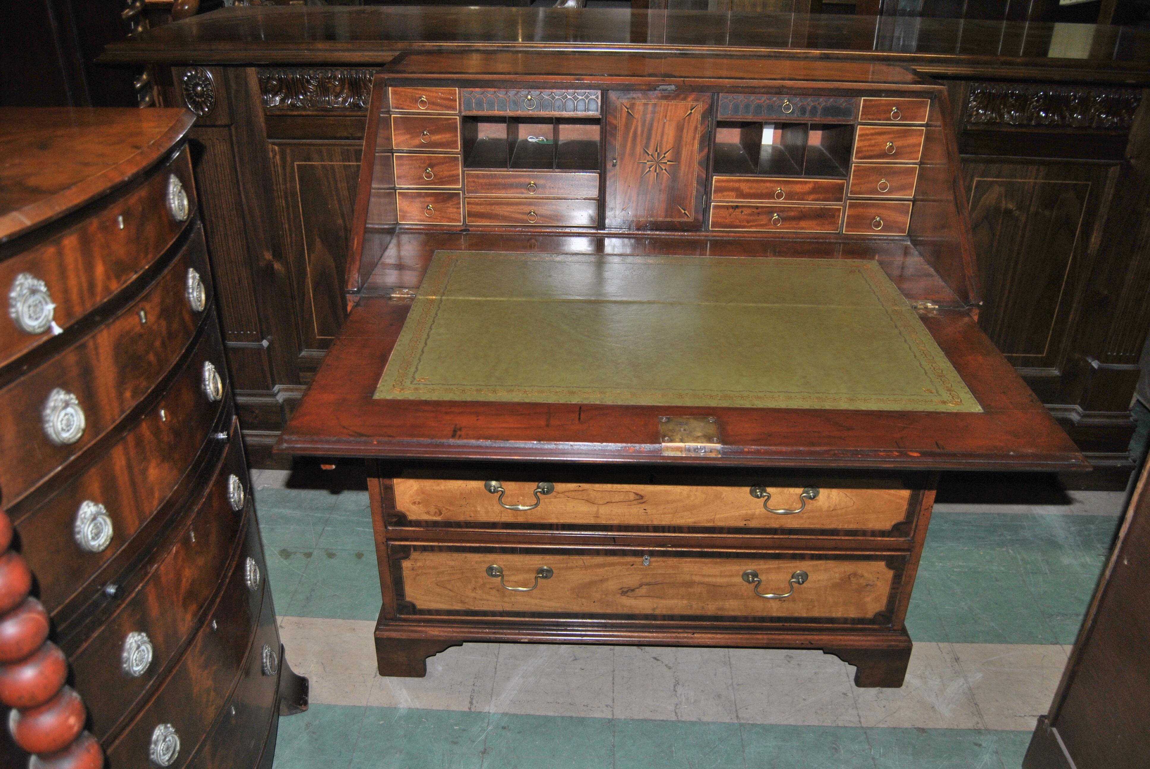 This is a secretary / bureau/ desk made in England, circa 1780. The top and the fall have a rosewood banding with a string inlay of satinwood and Satin Mahogany in the interior of the surface. All 5 of the drawers and both the right and left sides