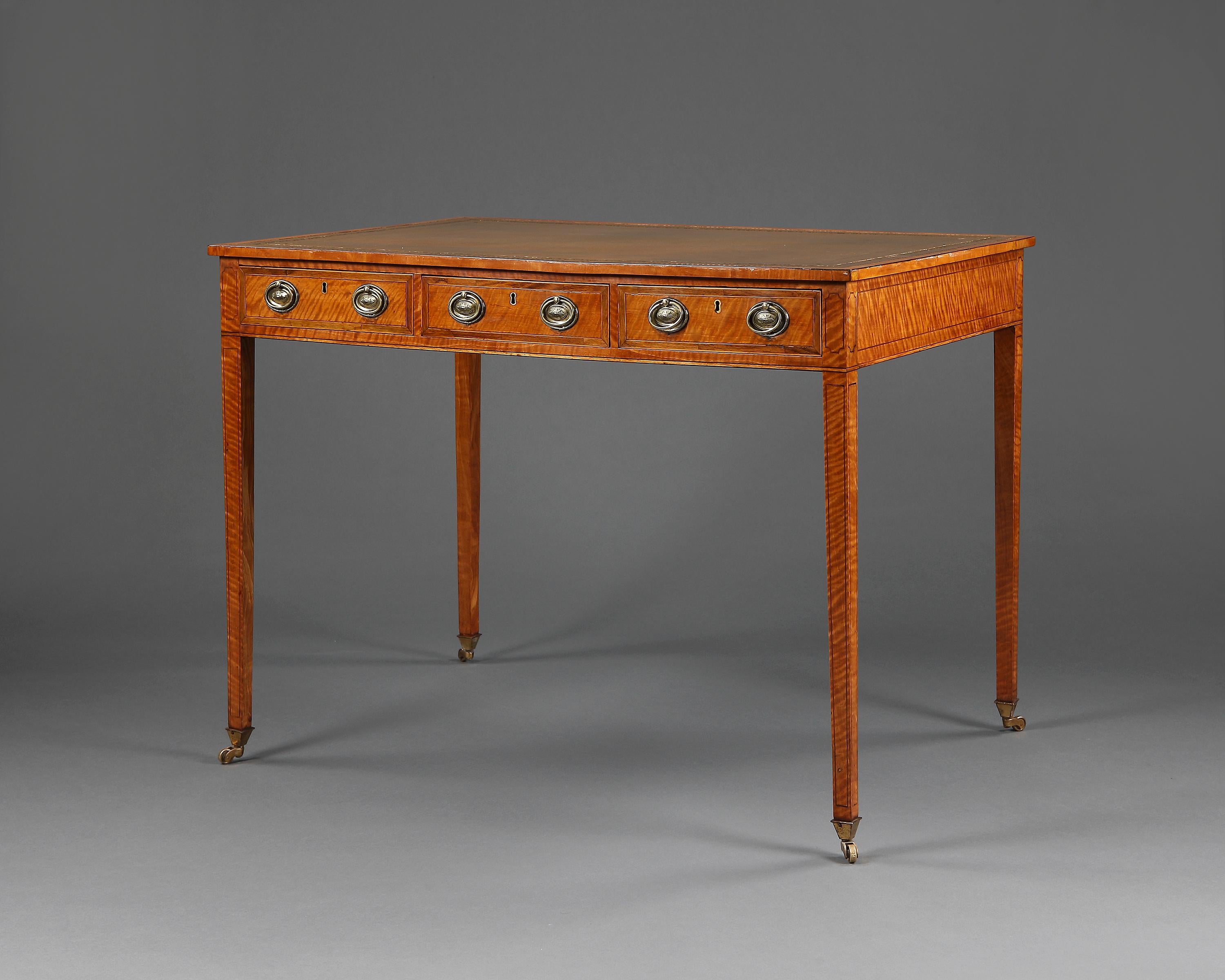 A very pretty six-drawer writing desk. Veneered in satinwood, crossbanded top which is edged in ebony. Measures: Height under the drawers 22 3/4 ins. Inset leather lined top over six frieze drawers, all having later oval brass handles. The whole is