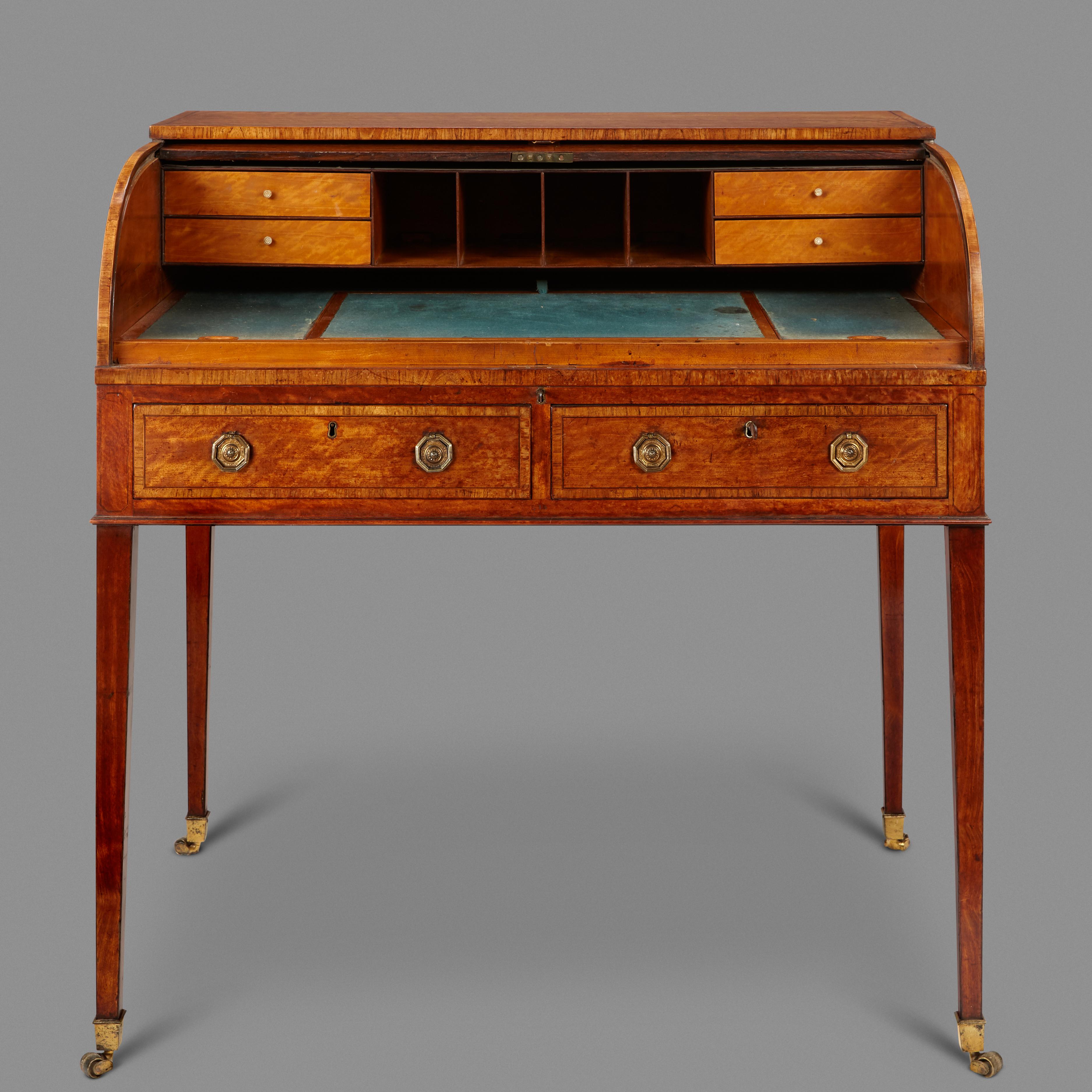 A Fine late 18th Century Writing Desk Veneered in Richly fFgured West Indian Satinwood. The inlaid tambour top opens to reveal a fitted interior comprising drawers and an adjustable writing slope . The felt lining believed to be original. The two