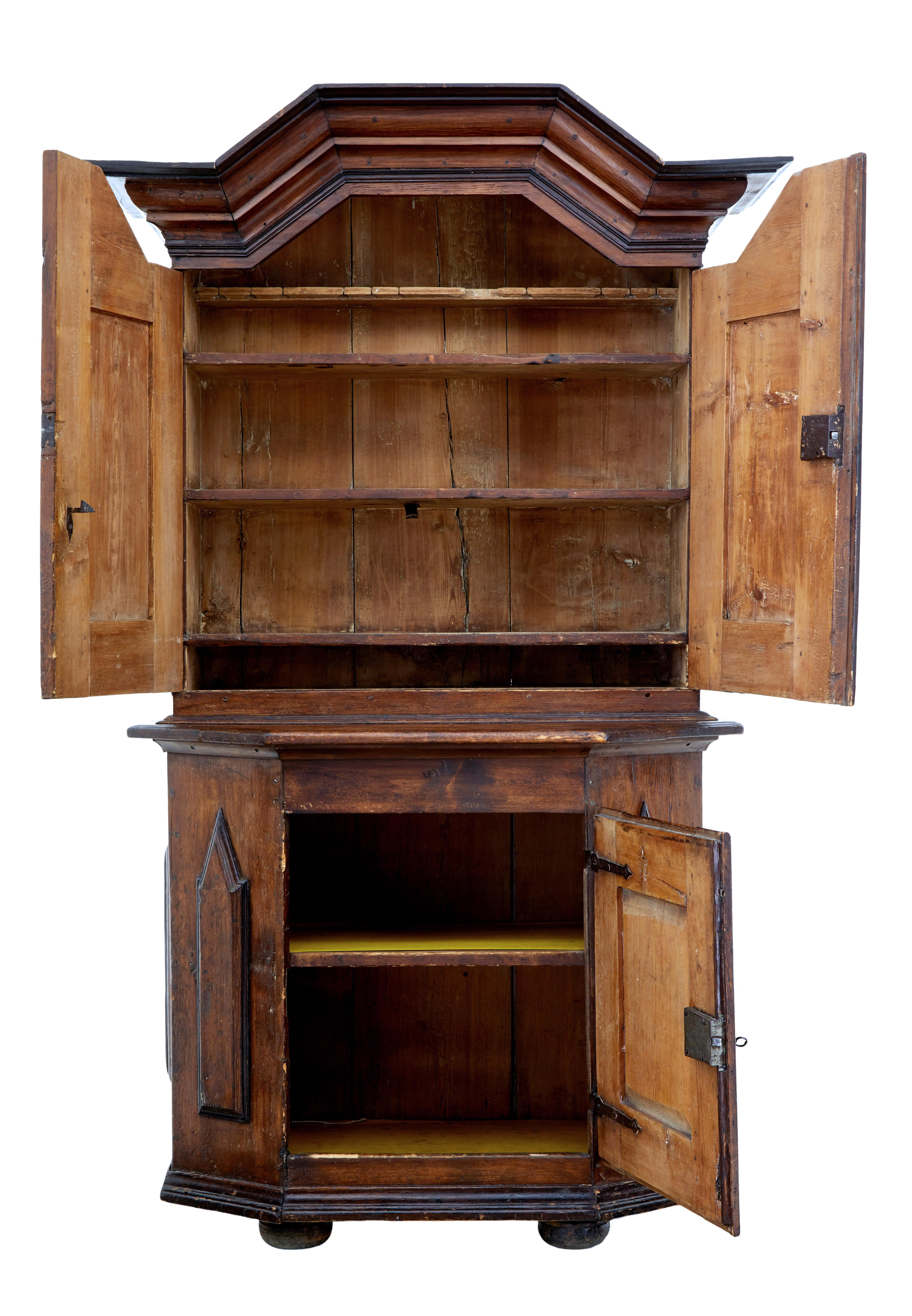 Rustic Swedish 2 part Baroque cupboard circa 1790.

Stained pine Baroque cupboard, a real piece of Scandinavian rustic made furniture. Shaped cornice below and double door cupboard containing various fixed shelves. Shaped bottom section with a