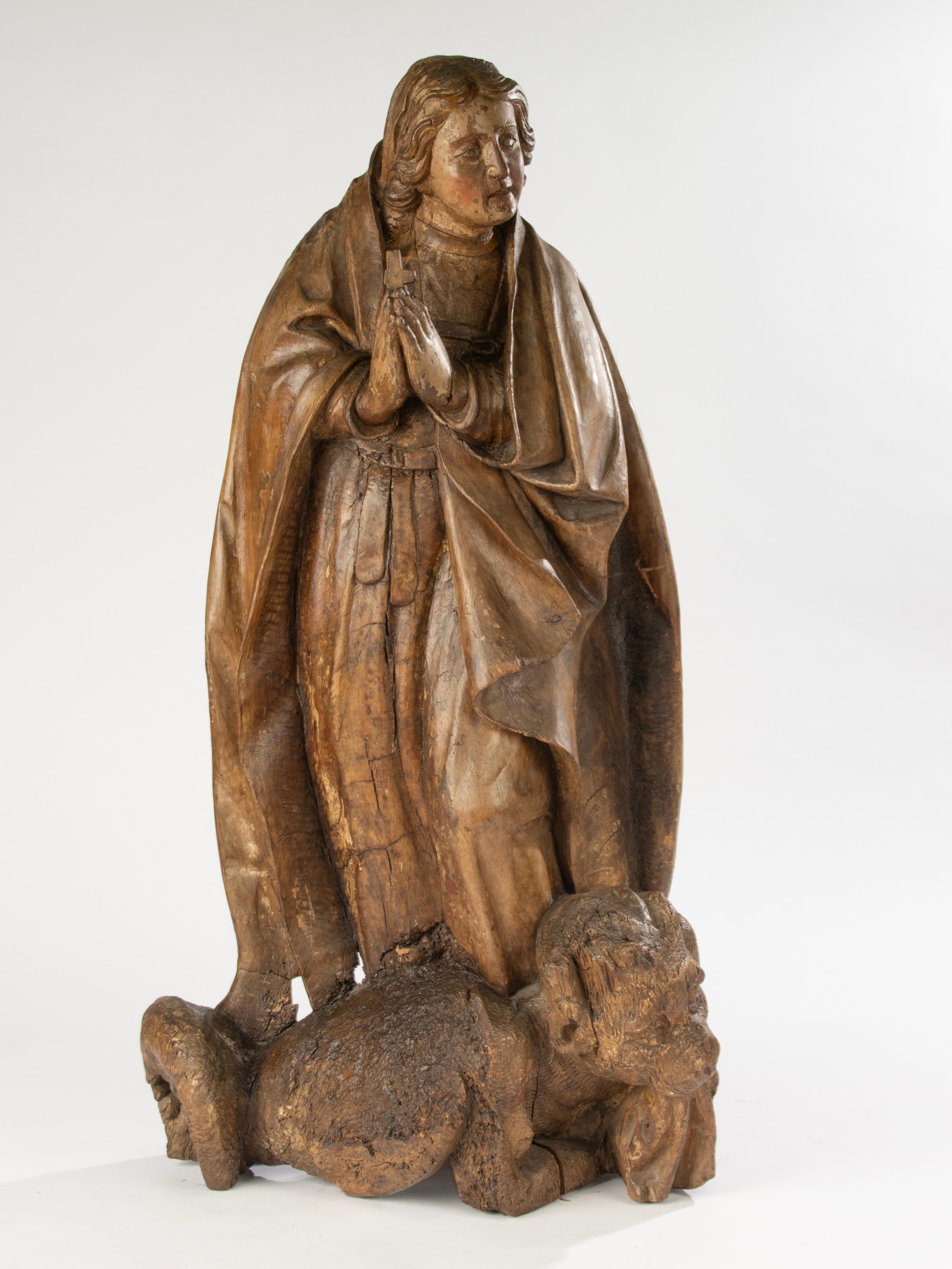 A large and atmospheric 18th century carved wooden statue of Saint Margaret, most likely originating from Spain. Executed in chestnut wood, with traces of its original polychrome still visible. The sculpture shows the saint in a devotional pose,
