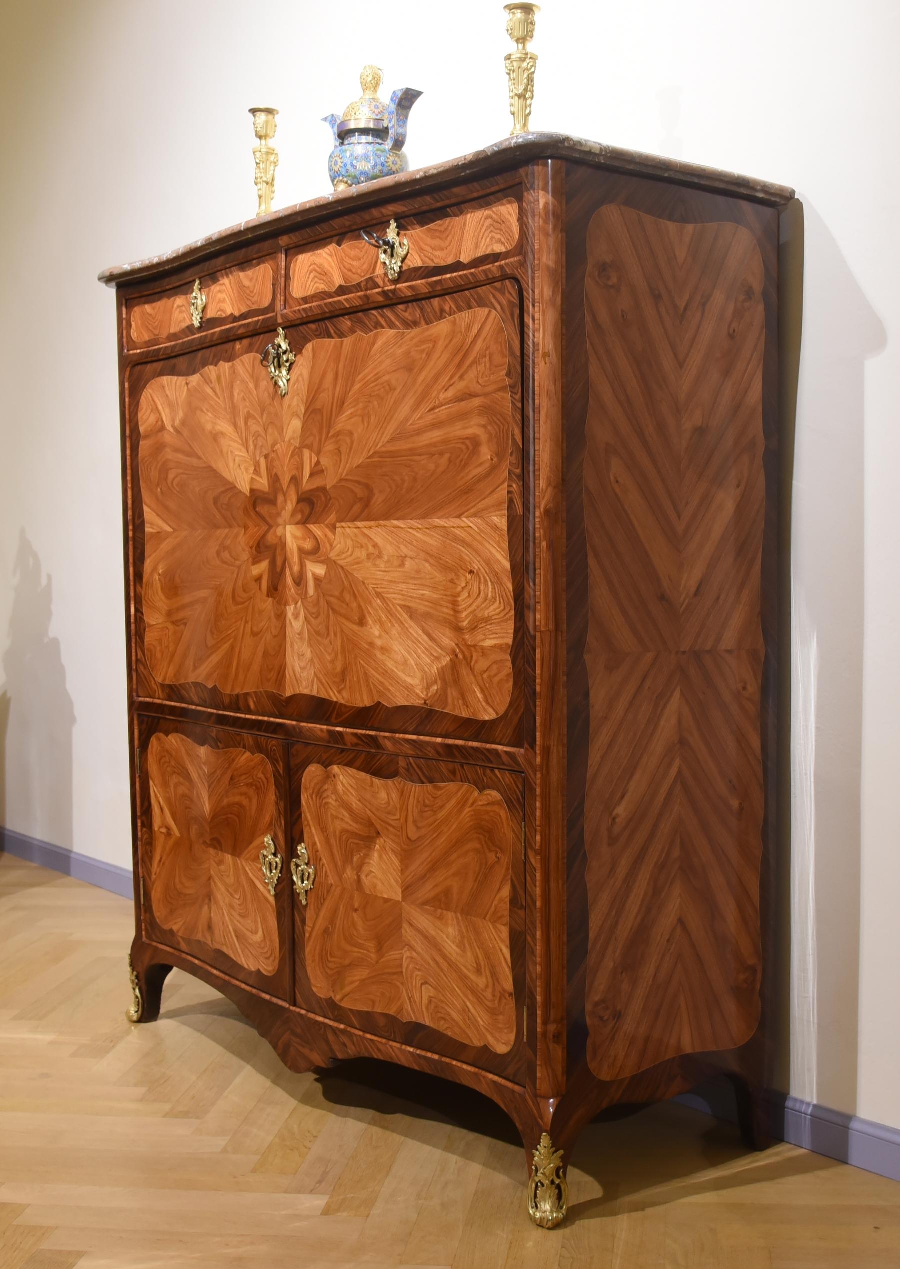 Refined Secretaire, Louis XV style, Lastronato with different woods: walnut, rosewood and oak, the wood motifs are butterfly with open leaf stain. The top marble is red, 8 internal drawers plus two doors with shelves. The decorations are in gilded