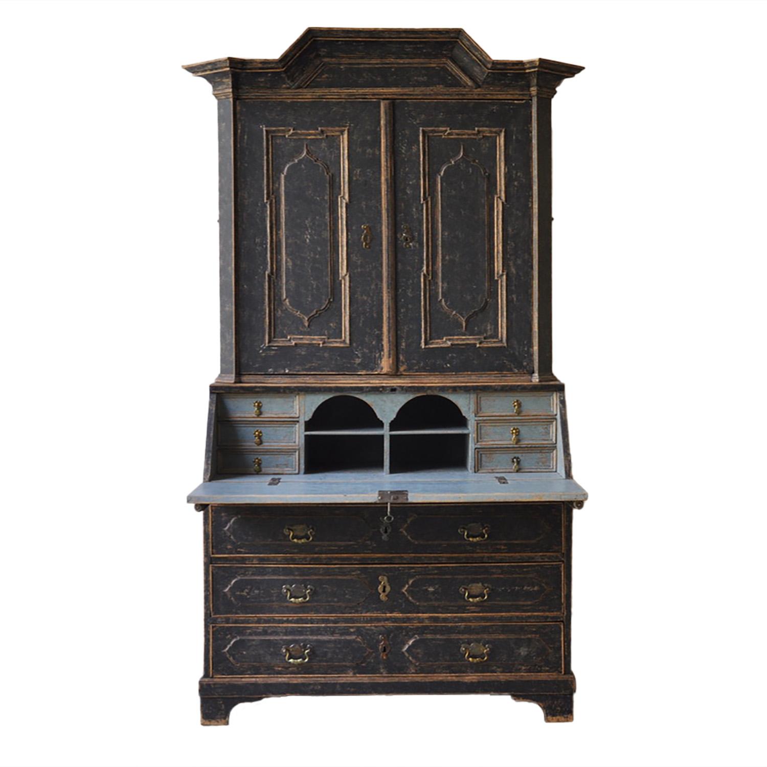 18th Century secretary with a decorative carved pediment. Two doors open to six drawers, and another small door opens to further drawers. A fall front desk with six further drawers and two pigeon holes, and below, three long drawers. Later hardware,