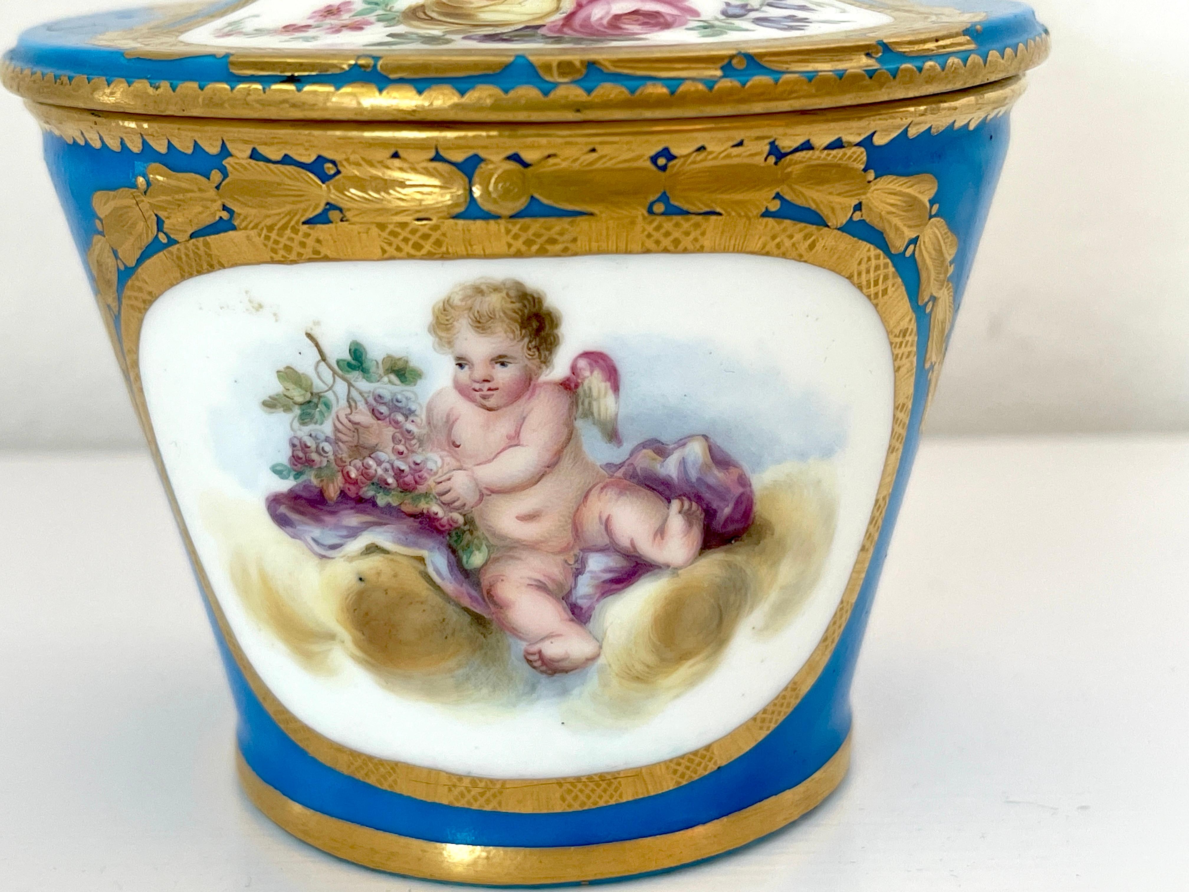 18th Century Sevres Blue Celeste Putti Motif Sugar Box 1767, Special Order
With an uncommon interlaced L mark in gold, Date letter O, with painter/gilder marks 
Its been suggested the gold Sevres mark denotes a special order. 

We are pleased to