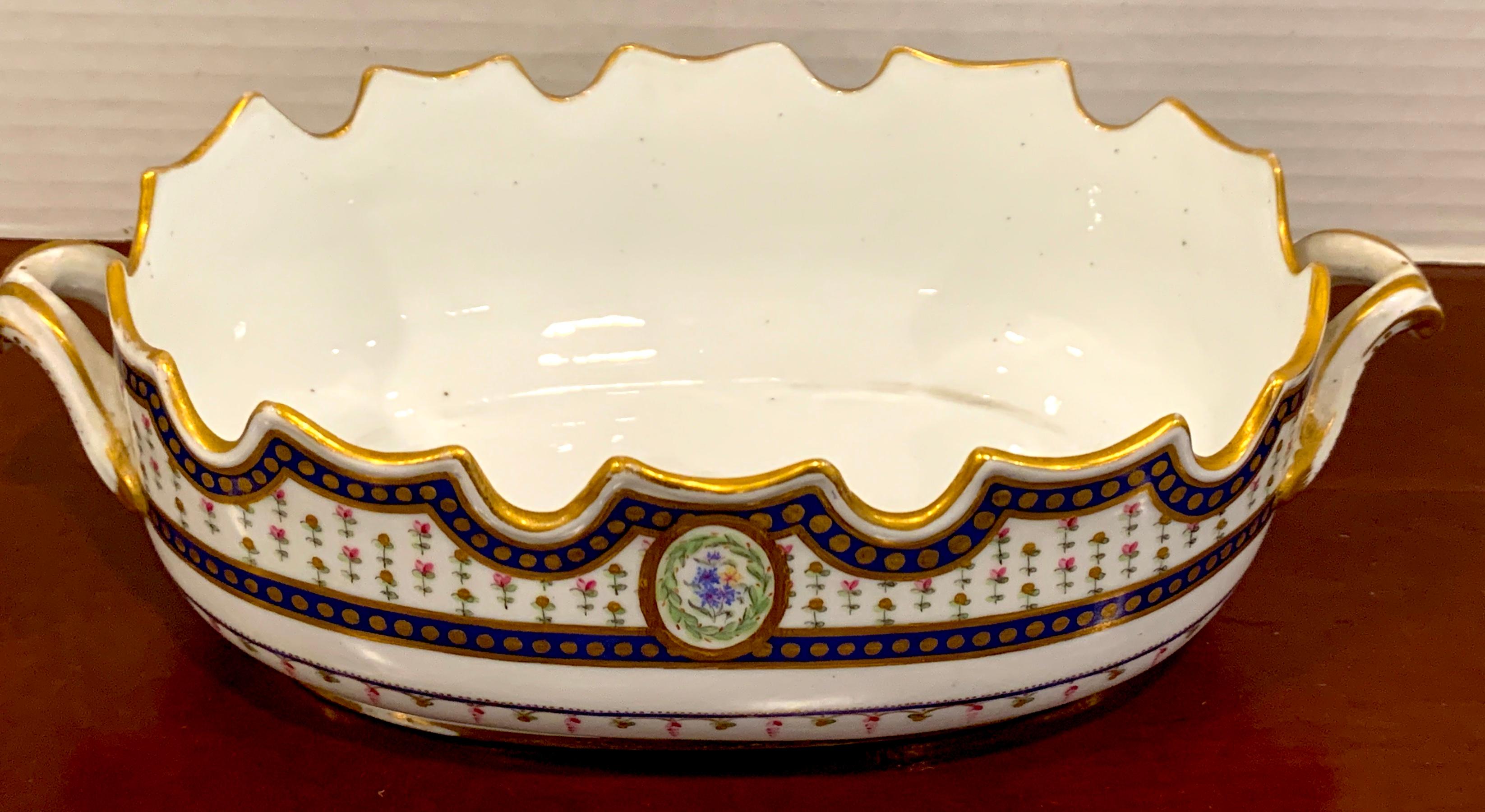 18th century Sevres Porcelain floral painted Monteith bowl, 1793, of typical form with twin handles and scalloped rim, painted with two different front and back floral vignettes. The interior measures 9