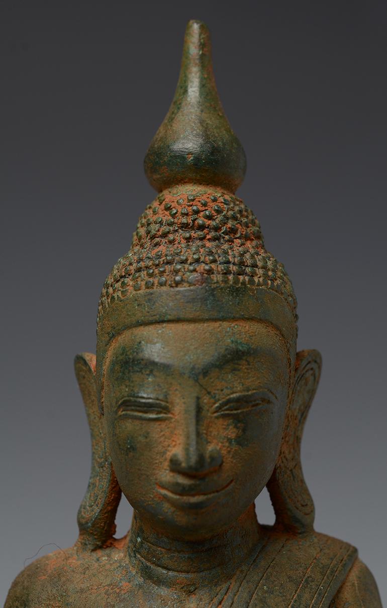 Burmese bronze Buddha sitting in Mara Vijaya (calling the earth to witness) posture on a base.

Age: Burma, Shan Period, 18th Century
Size: height 25.7 cm / width 16.1 cm.
Condition: Nice condition overall (some expected degradation due to its