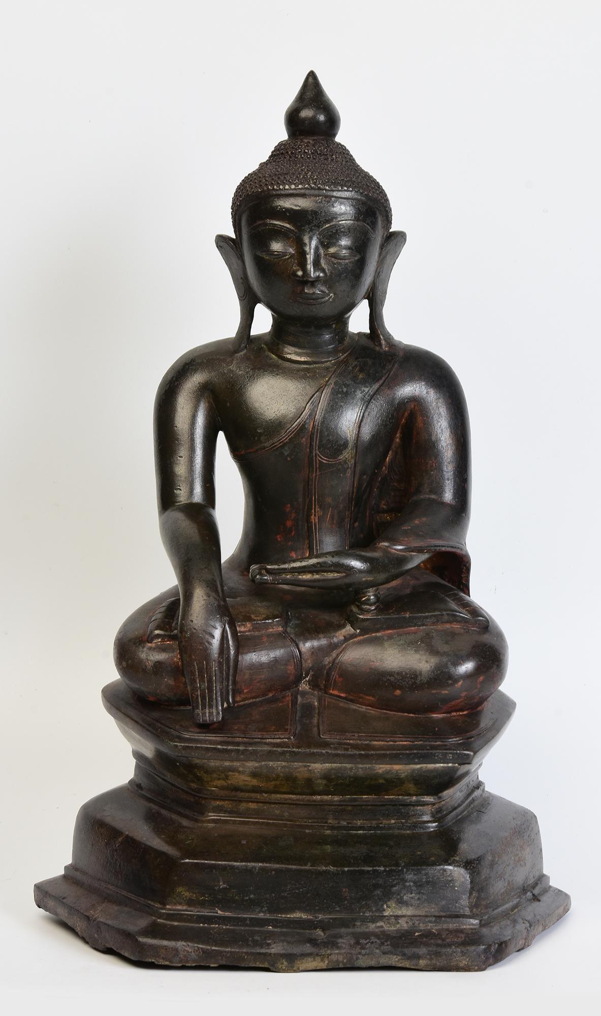 Antique Burmese bronze Buddha sitting in Mara Vijaya (calling the earth to witness) posture on a base.

Age: Burma, Shan Period, 18th Century
Size: Height 43.5 C.M. / Width 27 C.M. / Depth 17 C.M.
Condition: Nice condition overall (some expected