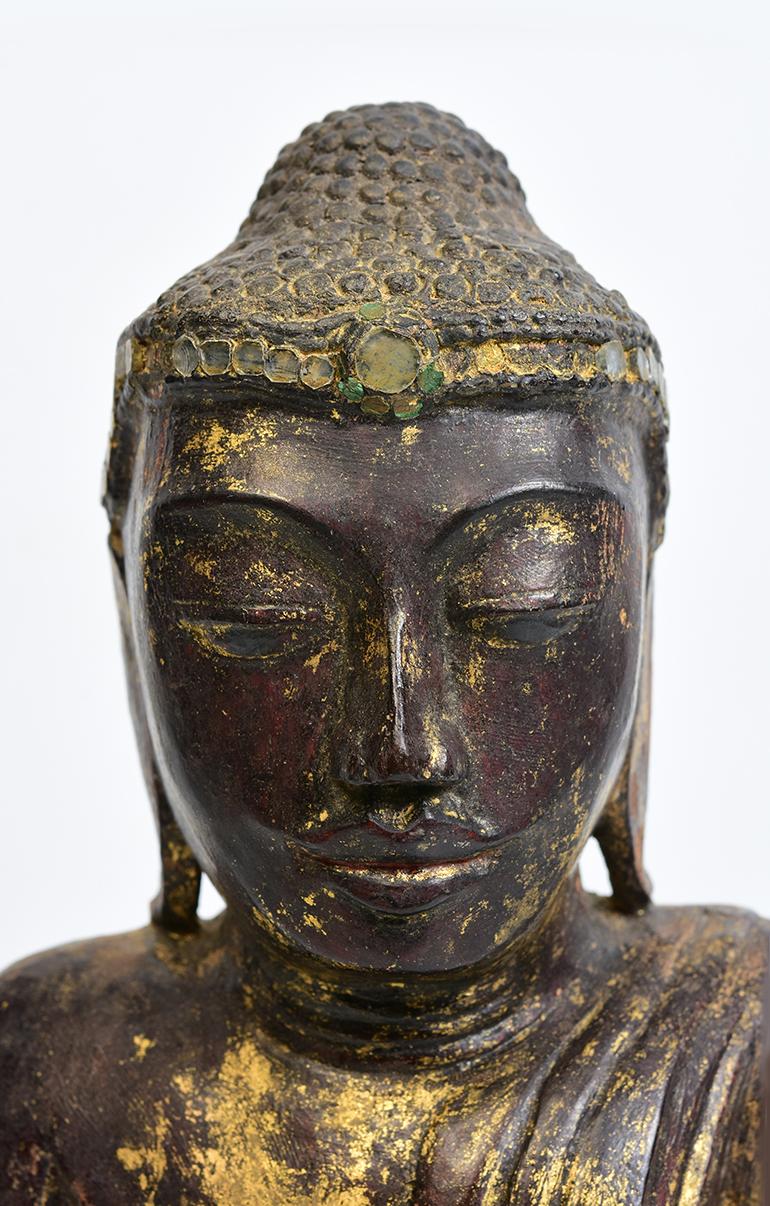 Burmese wooden Buddha sitting in Mara Vijaya (calling the earth to witness) posture on a base.

Age: Burma, Shan Period, 18th century
Size: height 41 cm / width 19.2 cm.
Condition: Nice condition overall (some expected degradation due to its