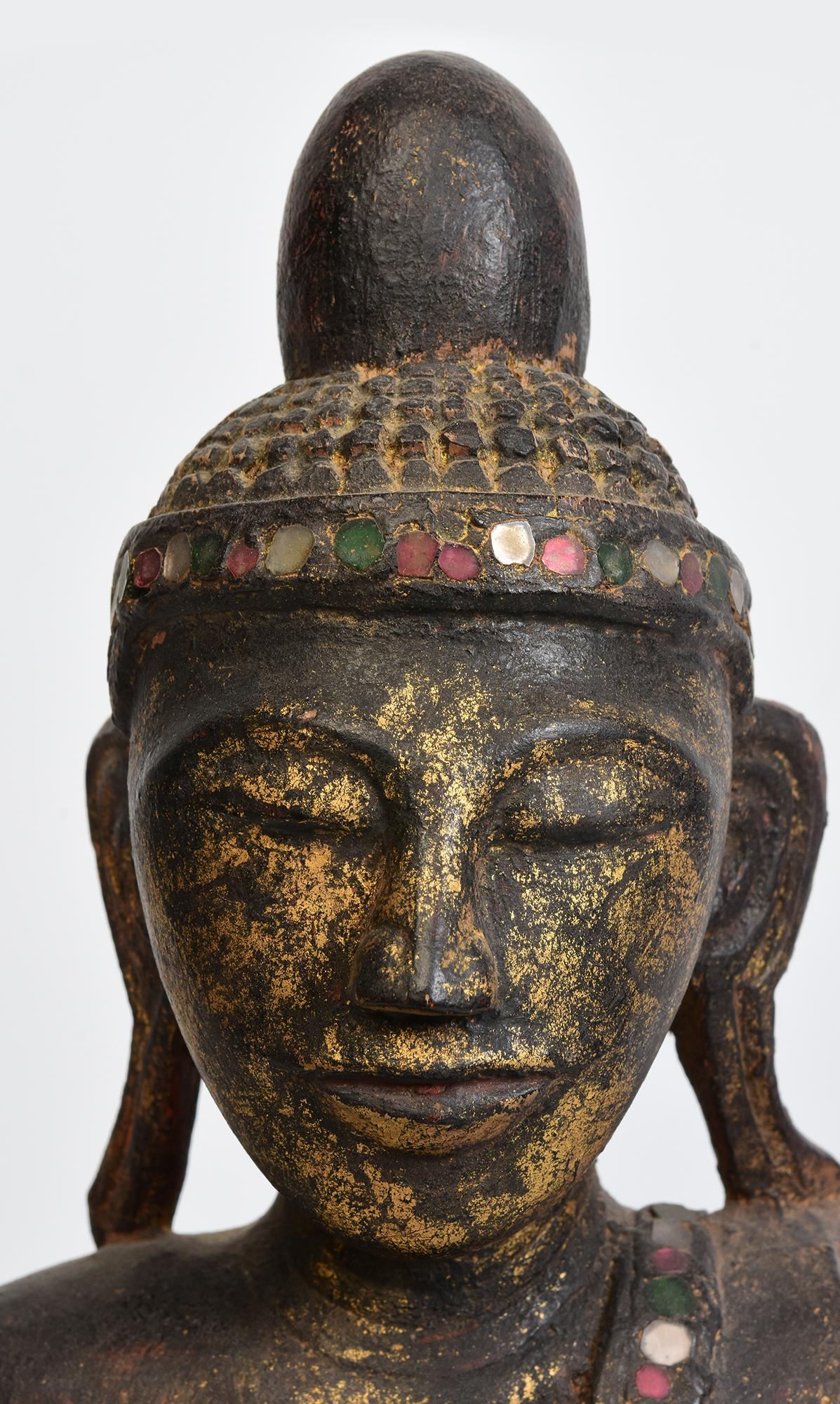 Antique Burmese wooden Buddha sitting in Mara Vijaya (calling the earth to witness) posture on a base.

Age: Burma, Shan Period, 18th Century
Size: Height 52 C.M. / Width 23.8 C.M. / Depth 14.5 C.M.
Condition: Nice condition overall (some expected