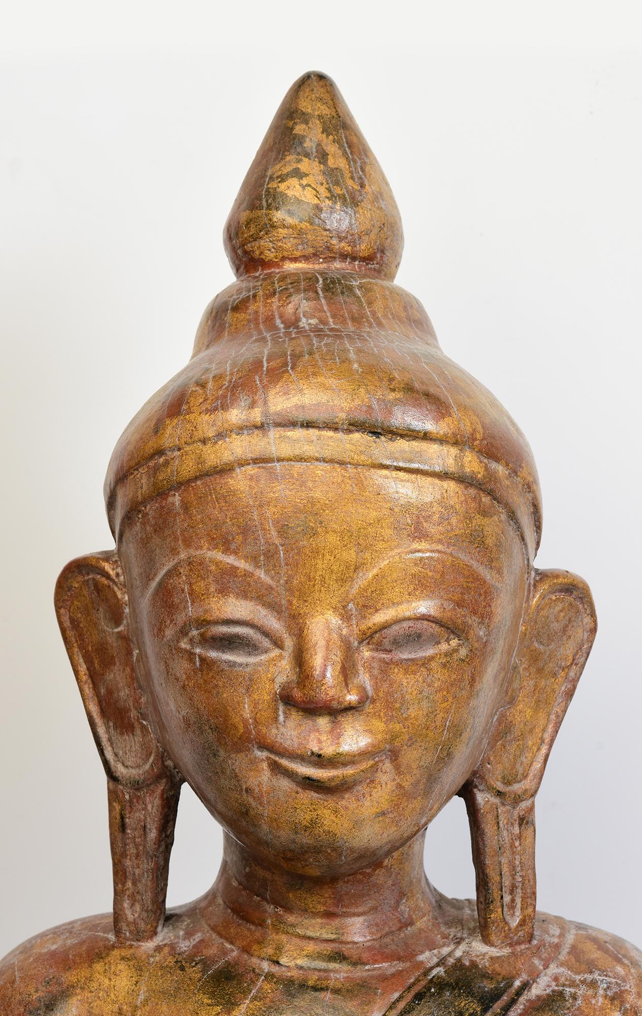 Antique Burmese wooden Buddha sitting in Mara Vijaya (calling the earth to witness) posture on a base.

Age: Burma, Shan Period, 18th Century
Size of Buddha only: Height 59.5 C.M. / Width 31 C.M. / Depth 27 C.M.
Height including stand: 61.3