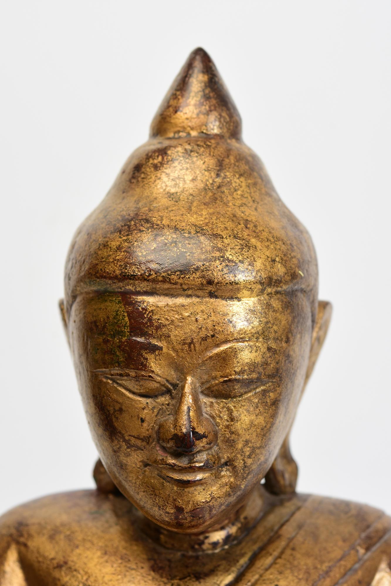 Bouddha ancien en bois birman assis en posture Mara Vijaya (appelant la terre à témoin) sur une base avec de l'or doré.

Age : Birmanie, Période Shan, 18ème siècle
Dimensions : Hauteur 39.6 C.M. / Largeur 21.3 C.M. / Profondeur 17.5 C.M.
Condit :