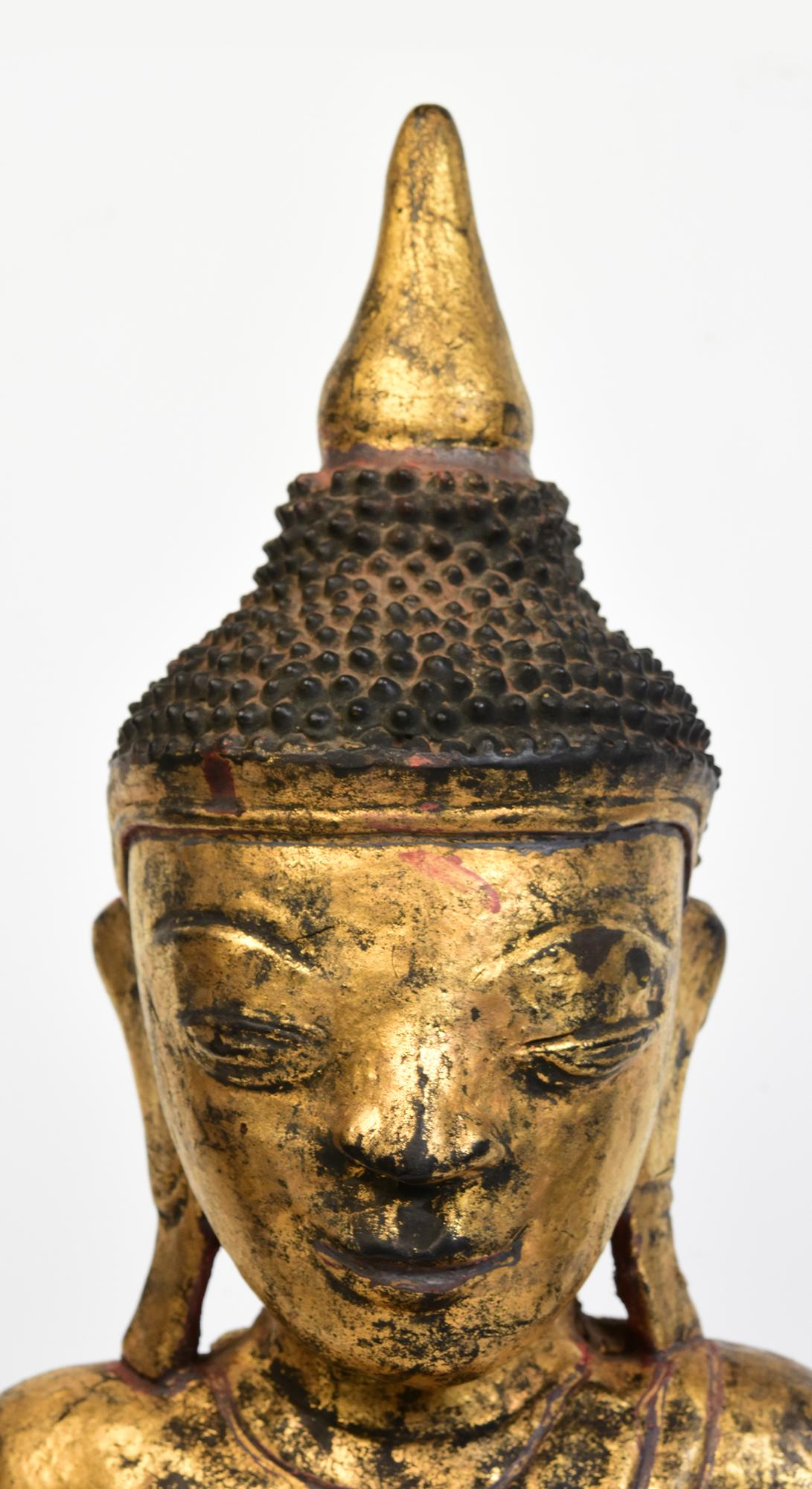 Antique Tai Yai Burmese wooden Buddha sitting in Mara Vijaya (calling the earth to witness) posture on a base with gilded gold and glass.

Age: Burma, Shan Period, 18th Century
Size: Height 63.5 C.M. / Width 27.8 C.M. / Depth 15 C.M.
Condition: Nice