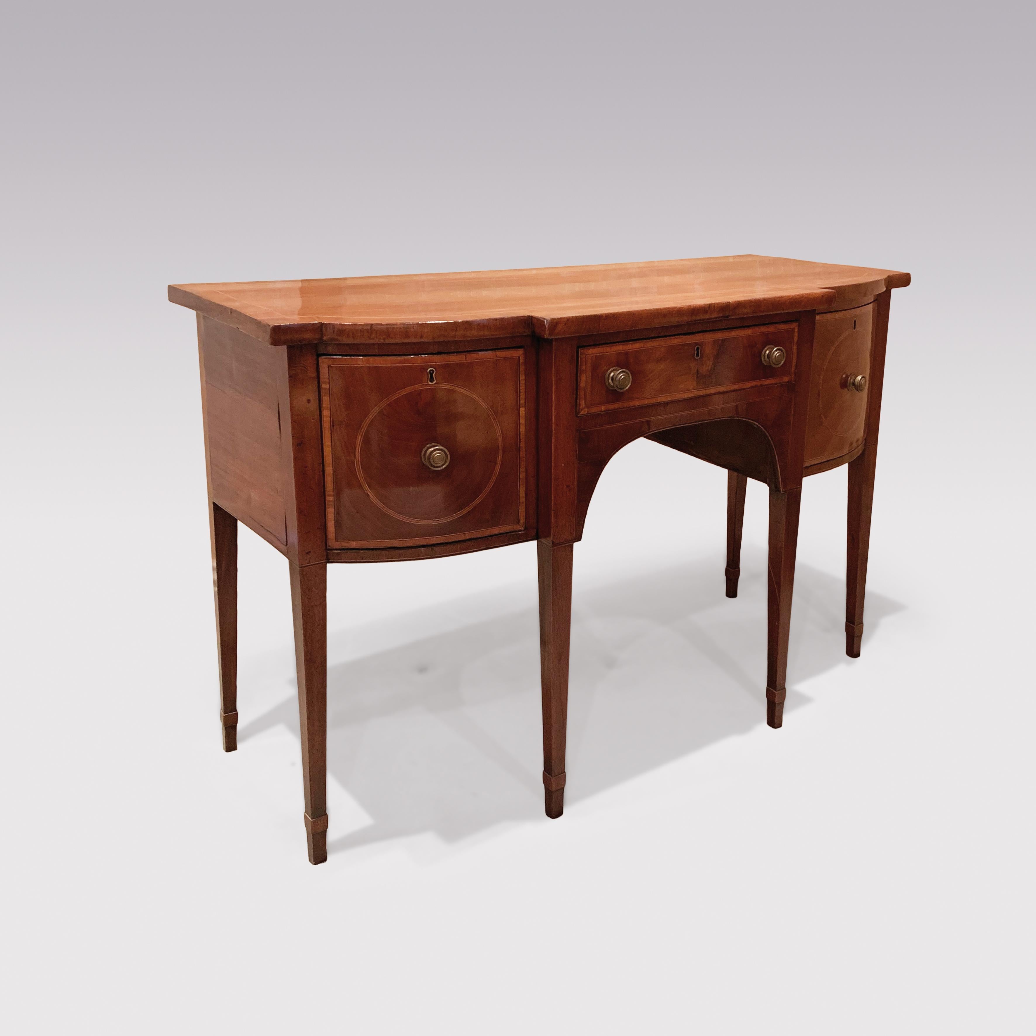 A late 18th century Sheraton period mahogany breakfront bowfront sideboard of attractive small proportions, boxwood and ebony strung throughout, having mahogany crossbanded top above satinwood crossbanded drawers, supported on square tapering legs