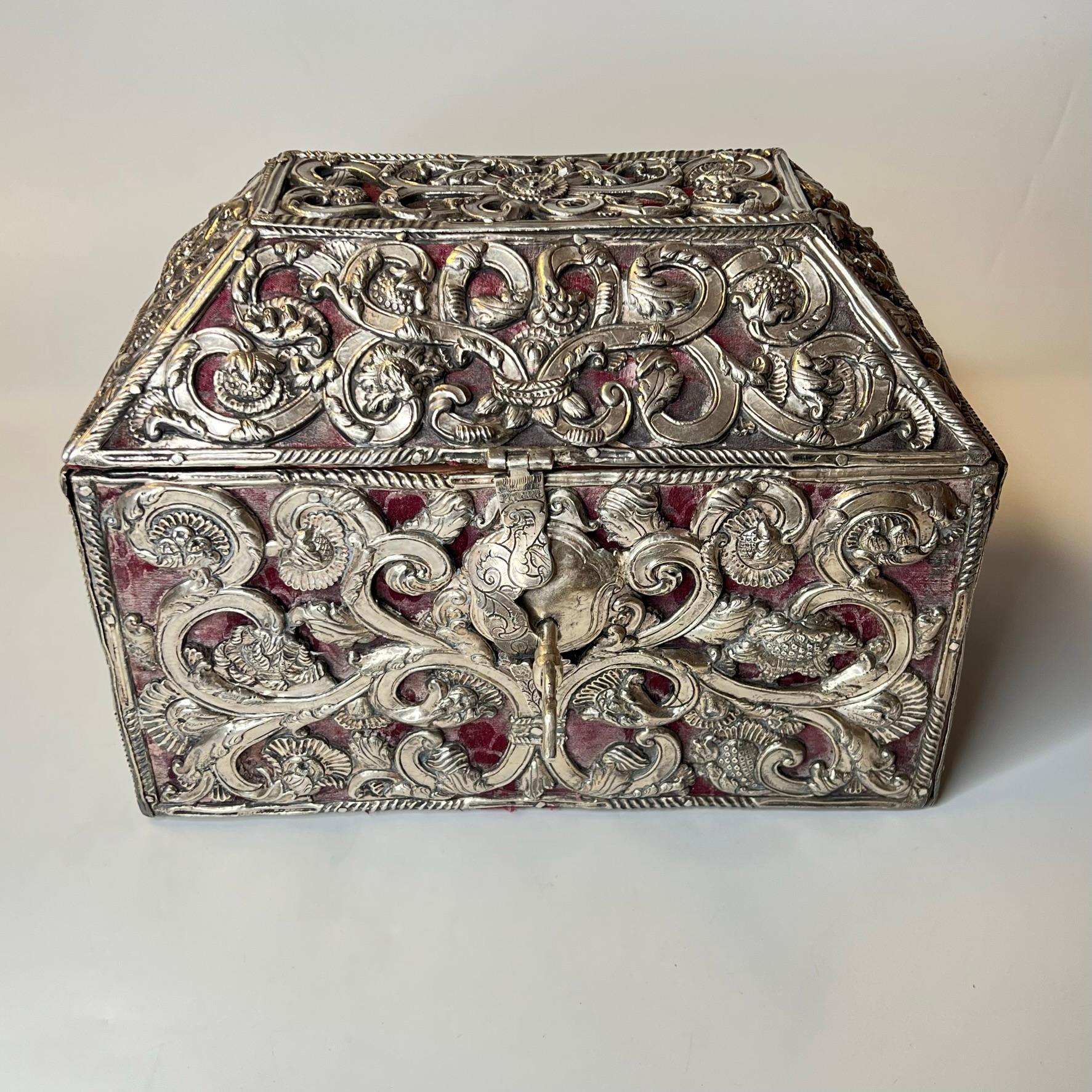 Our unique 18th century silver clad wooden chest, 9 by 10 by 14 inches, comes from South America, likely Brazil, and features elaborate vines and flowers and fruit in the Baroque style. Apparently unsigned and with its original key.