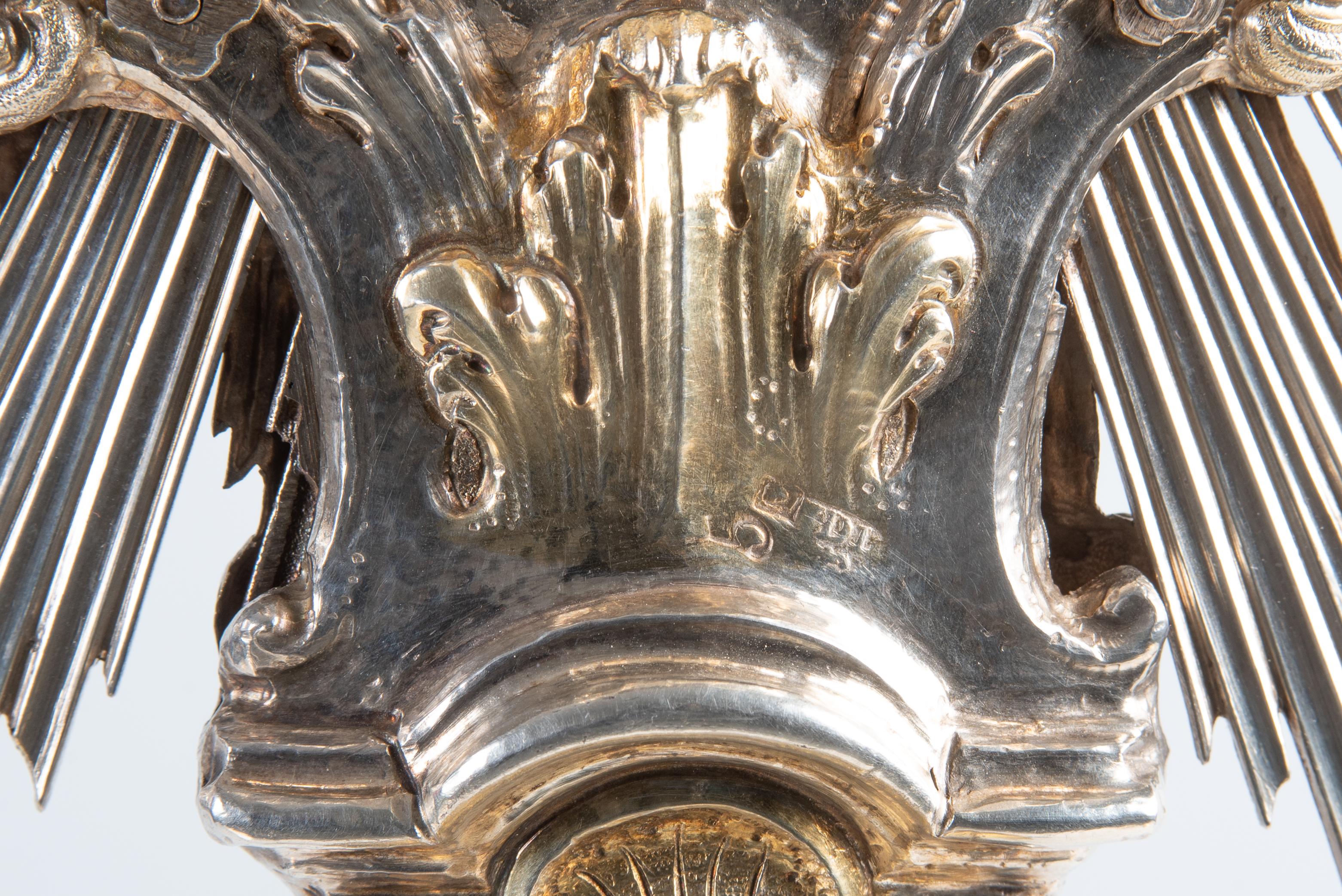 Ostensorio a raggiera in argento di Augsburg, 1797-1799 circa.

Maestro: A. Hermann David Lüders

Questo imponente ostensorio a raggiera della fine del XVIII secolo è stato realizzato ad Augusta tra il 1797 e il 1799 ed è in argento parzialmente