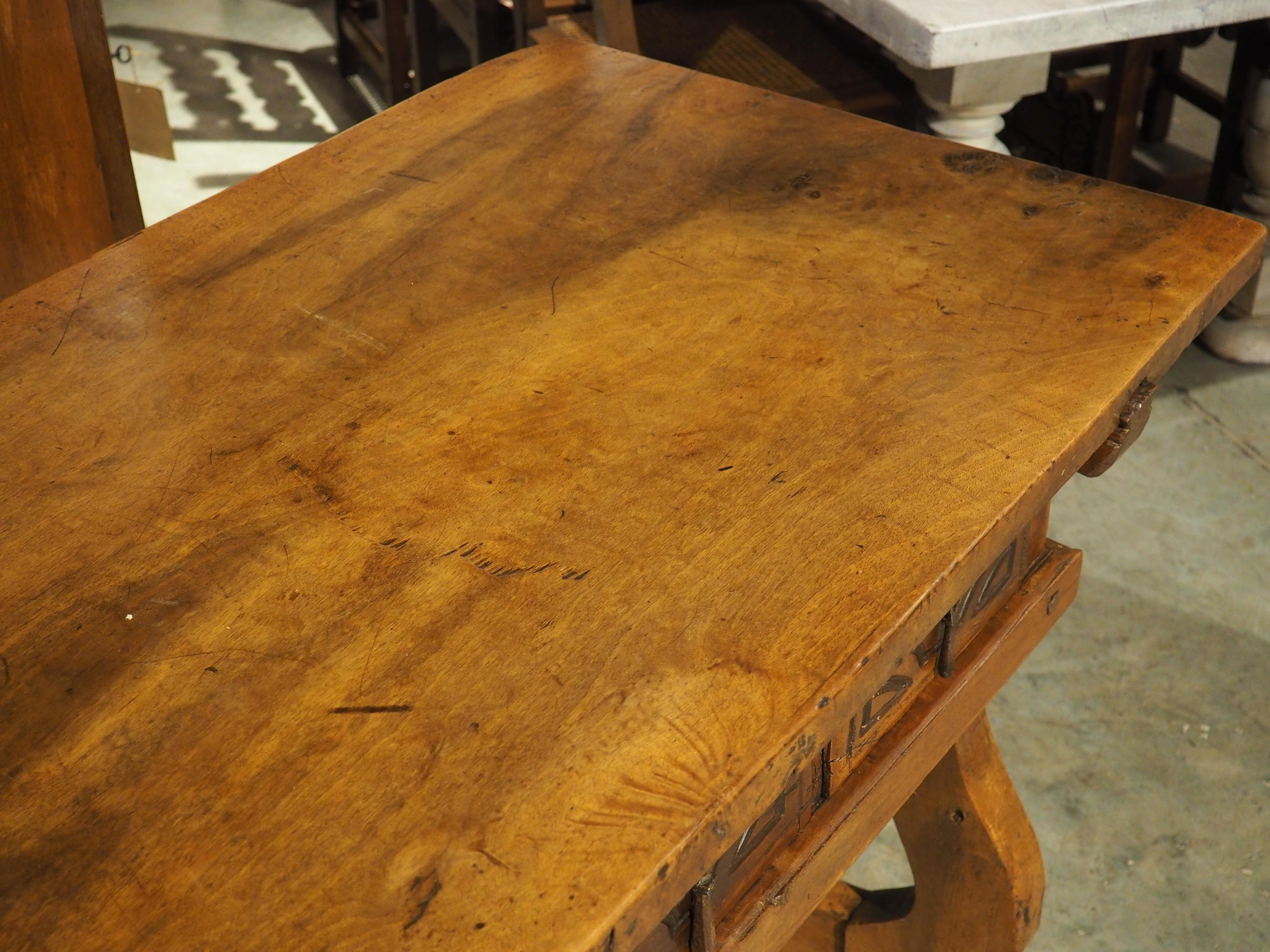 Plus d'informations bientôt...

Cette console à quatre tiroirs porte la marque des ébénistes espagnols du XVIIIe siècle.  Sculpté à la main dans du noyer, le plateau est constitué d'une seule planche.  Les pieds en lyre larges et ouverts sont de