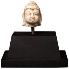 Piccola testa di Buddha antica in marmo del XVIII secolo su piedistallo, proveniente dall'India