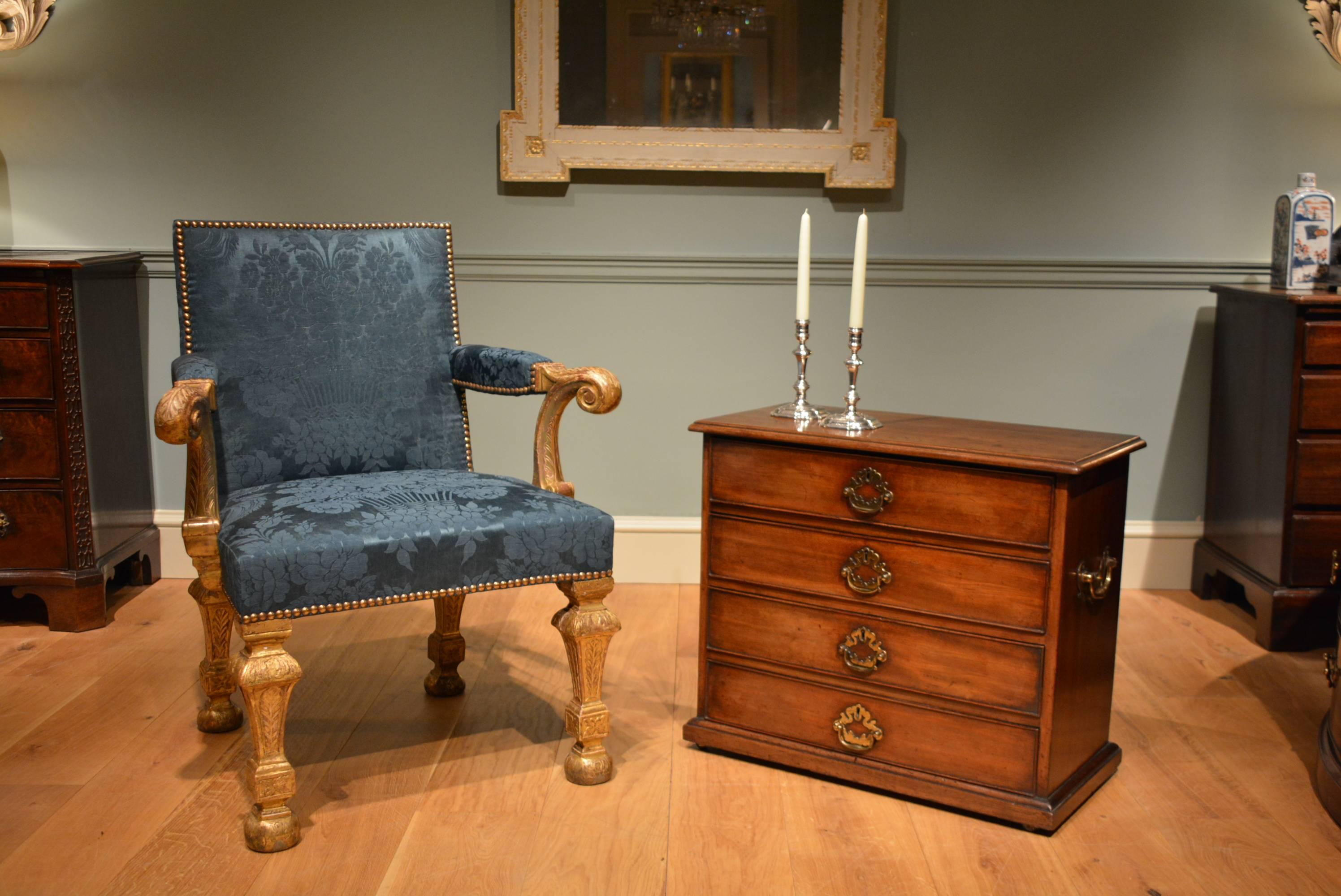 A George II small freestanding mahogany chest containing four drawers, each with its original handle, standing on a shallow plinth base which conceals castors.