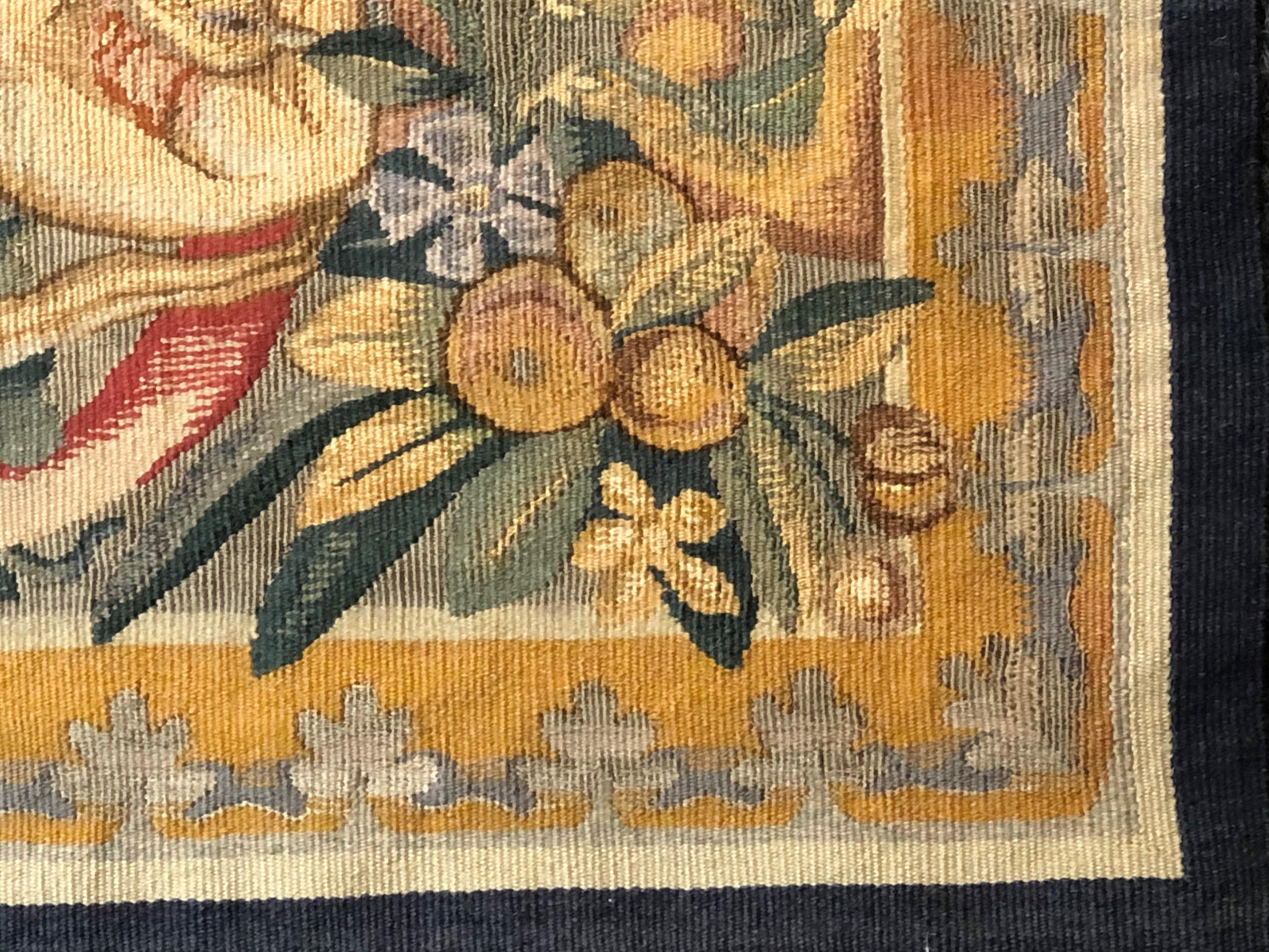 Small but precious this tapestry that comes from the French town of Aubusson. A decoration rich in flowers and fruits revolves around a fight scene between a feline and a bird of prey with a large plumage. The bloody scene contrasts with the