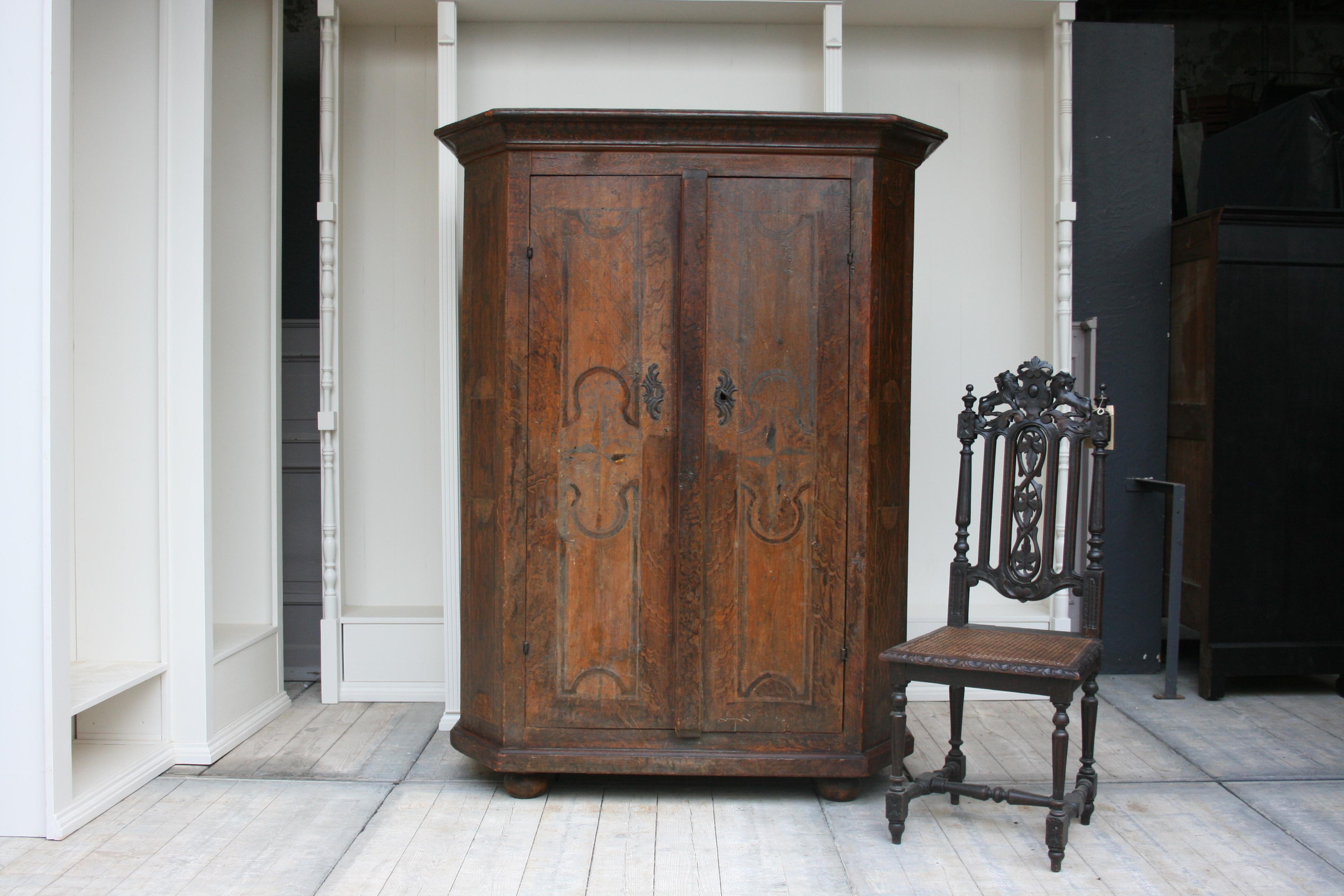 Antique South German rustic cabinet in original painting, circa late 18th century.
2-door corpus made of softwood with beveled corners on ball feet. Inside there are 4 shelves.

Dimensions:
173 cm high / 68.11 inch high,
134 cm wide / 52.75