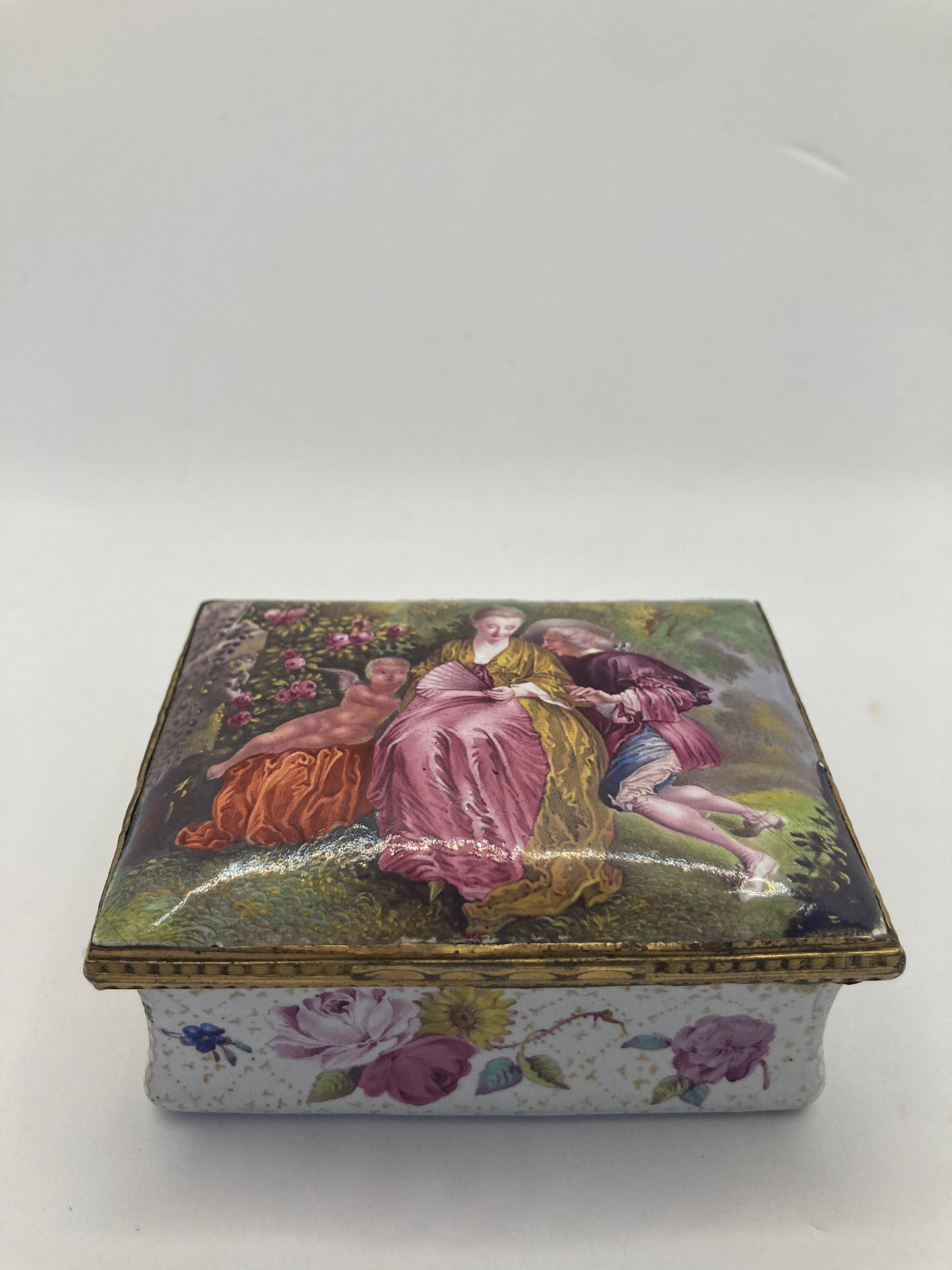 Caja de rapé de South Staffordshire del siglo XVIII, decorada con una pareja con Cupido en un parque, la base blanca con flores sobre un fondo de pañales dorados . 3.125