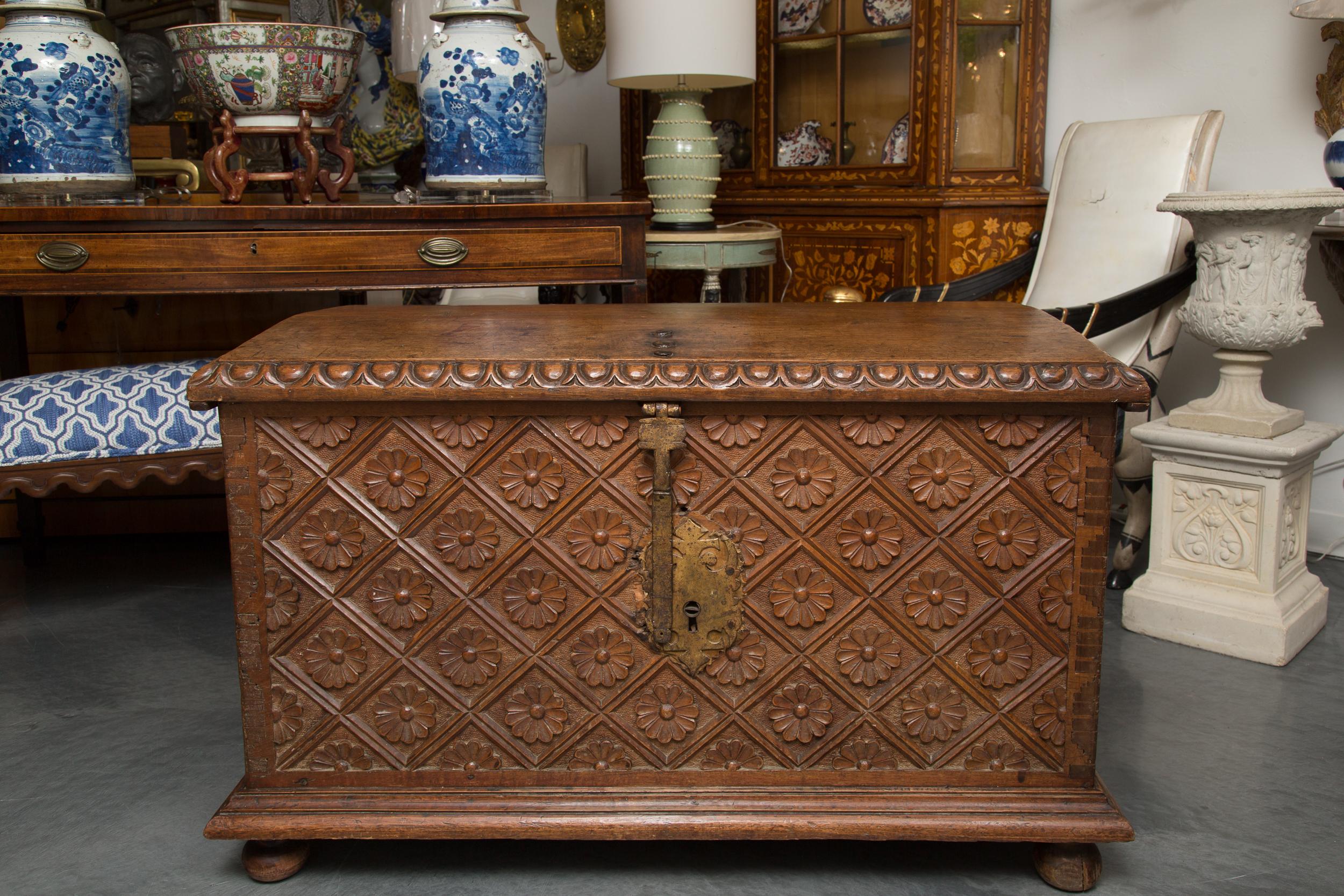 This is a northern Spain walnut blanket chest artfully carved over all with flower heads. The slightly arched top has an ogee edge with a carved motif reminiscent of an egg and dart design. The cassone is raised on small bun feet.