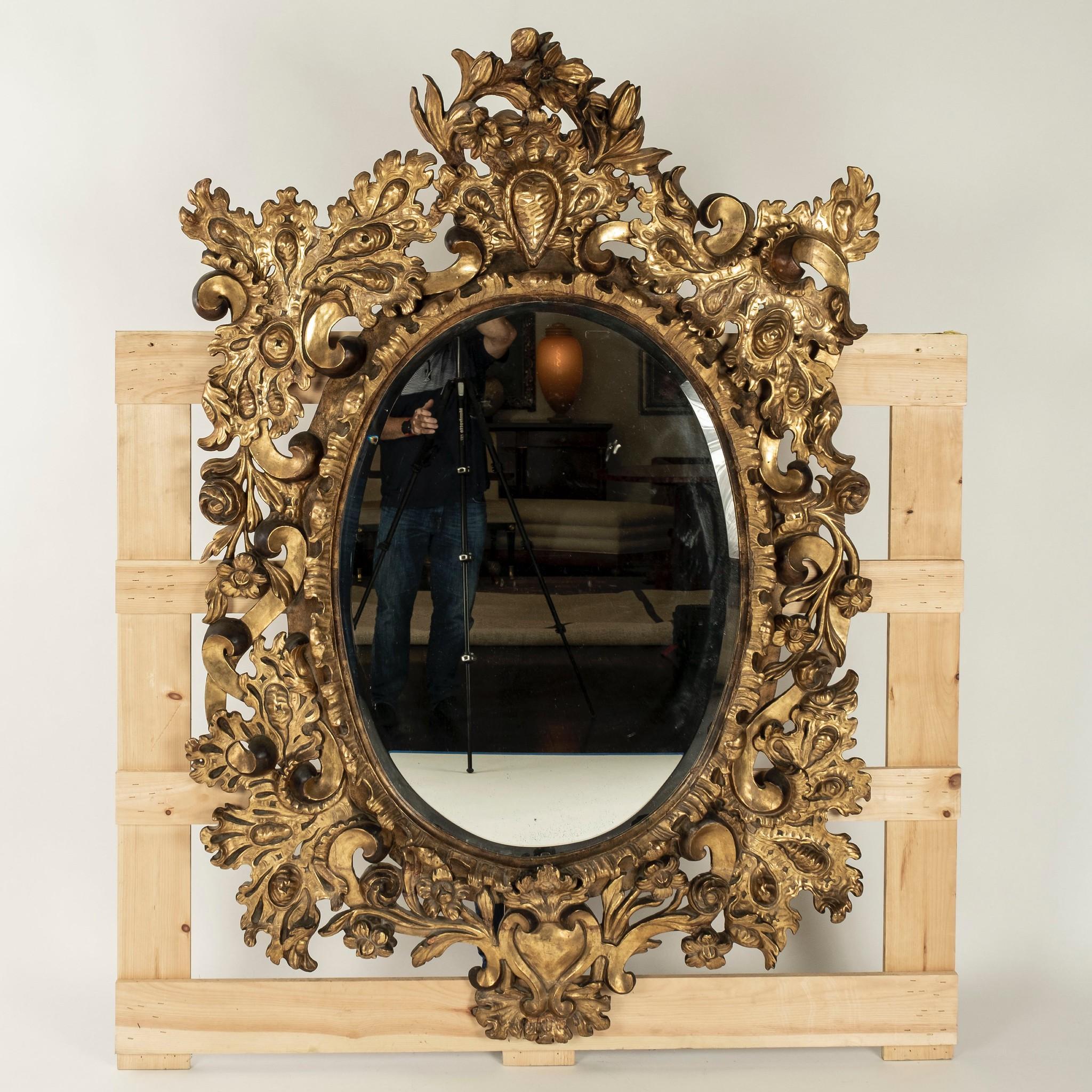 Large 18th century Spanish Baroque gilt wood oval mirror.
