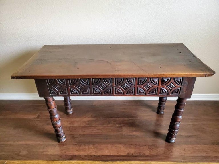 An outstanding one of a kind 18th century carved walnut refectory console table with exceptional patina and graining. Handcrafted in Spain, rustic architectural elements, beautifuuly aged single board plank top, over deeply carved geometric pattern