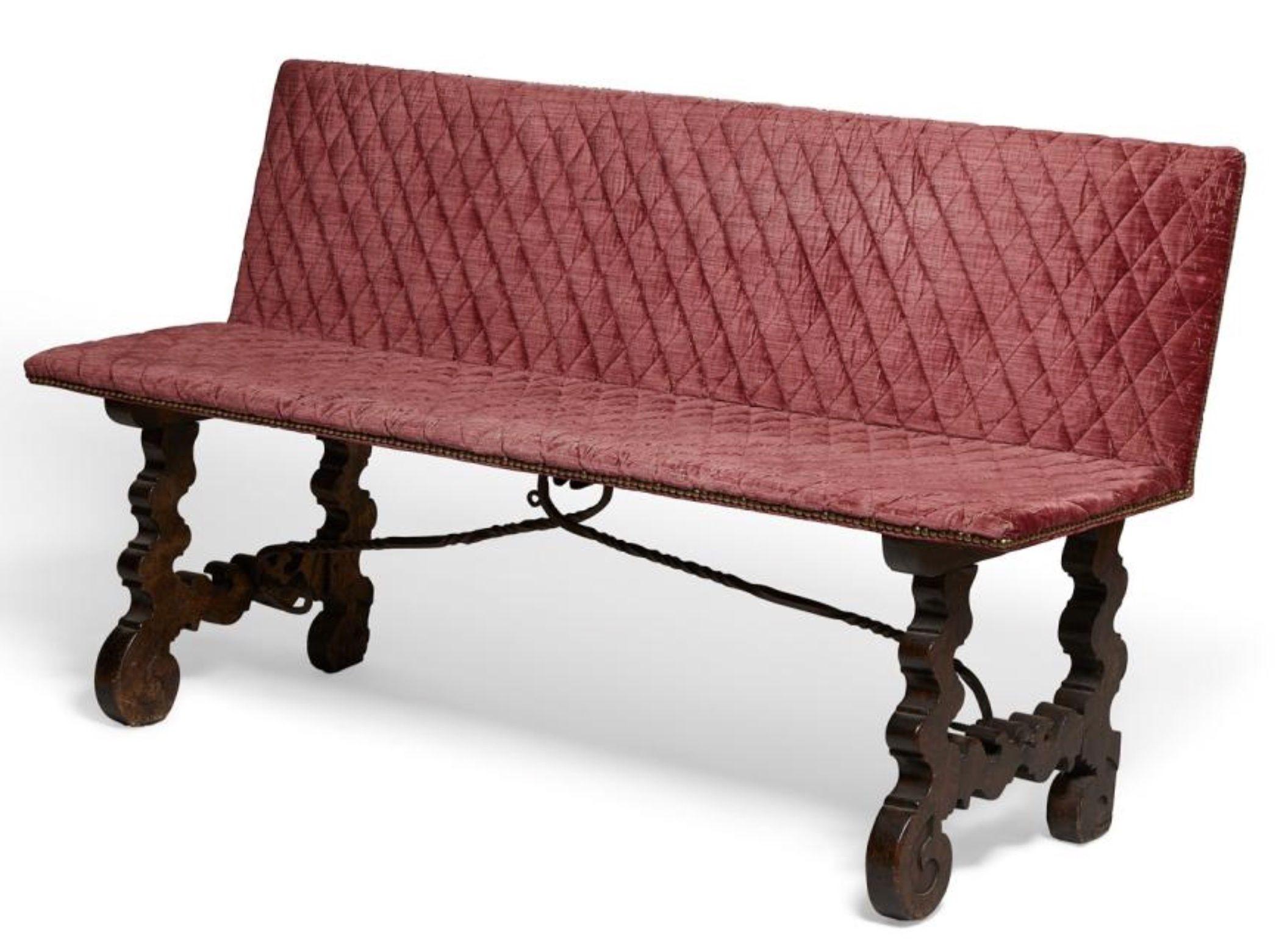 An 18th century Spanish Baroque style red velvet upholstered chestnut bench with wrought iron mounted brass.

Dimensions: Height 33 in. (84 cm), width 60 in. (153 cm), depth of seat 14.5 in. (37 cm) height of seat 19 in.