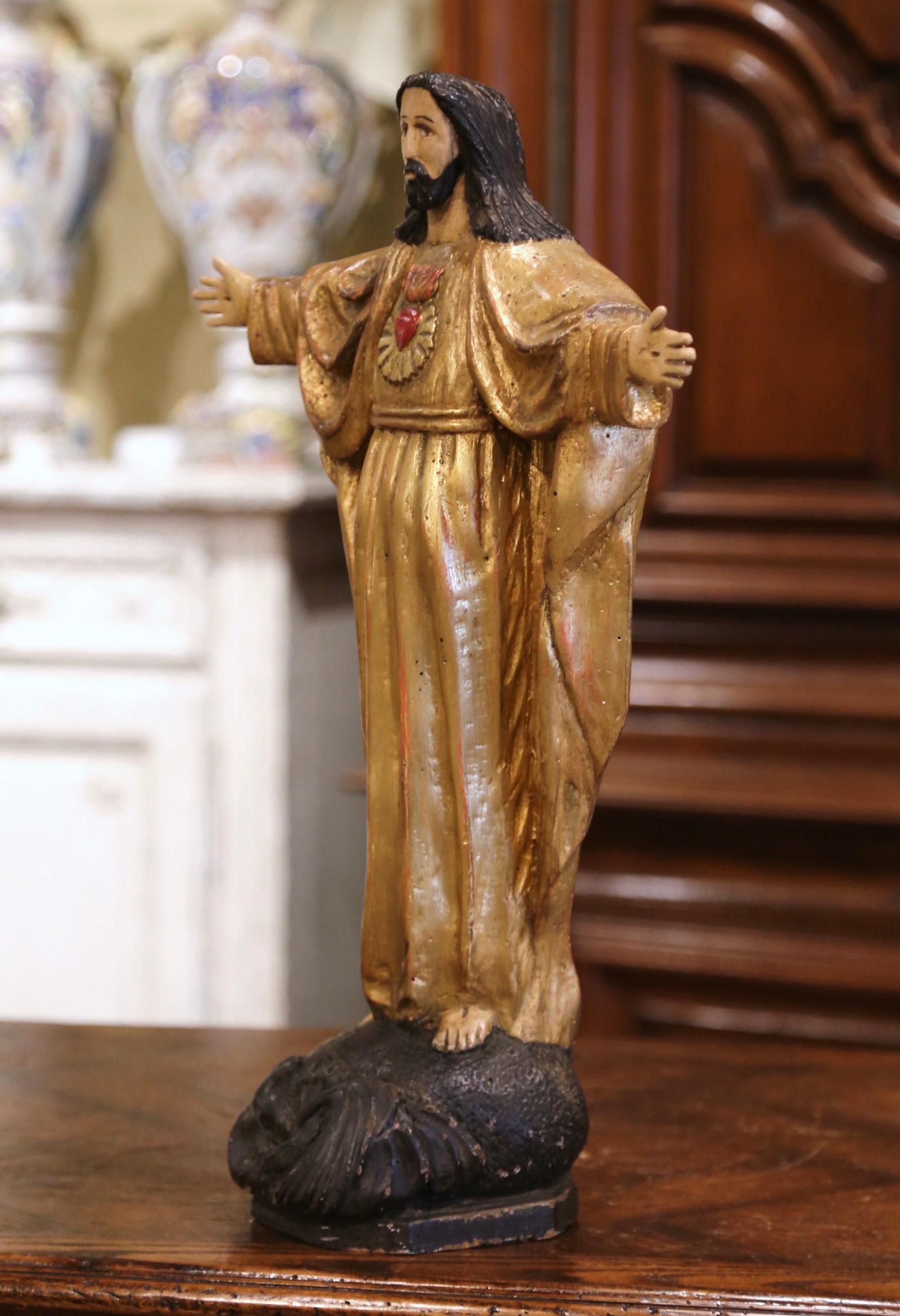 This beautiful antique Christ statue was hand carved in Spain, circa 1790. On a wooden base resembling rock with carved motifs, the sculpture depicts our Lord Jesus Christ standing with open arms and pierced hands, showing his Sacred Heart. The