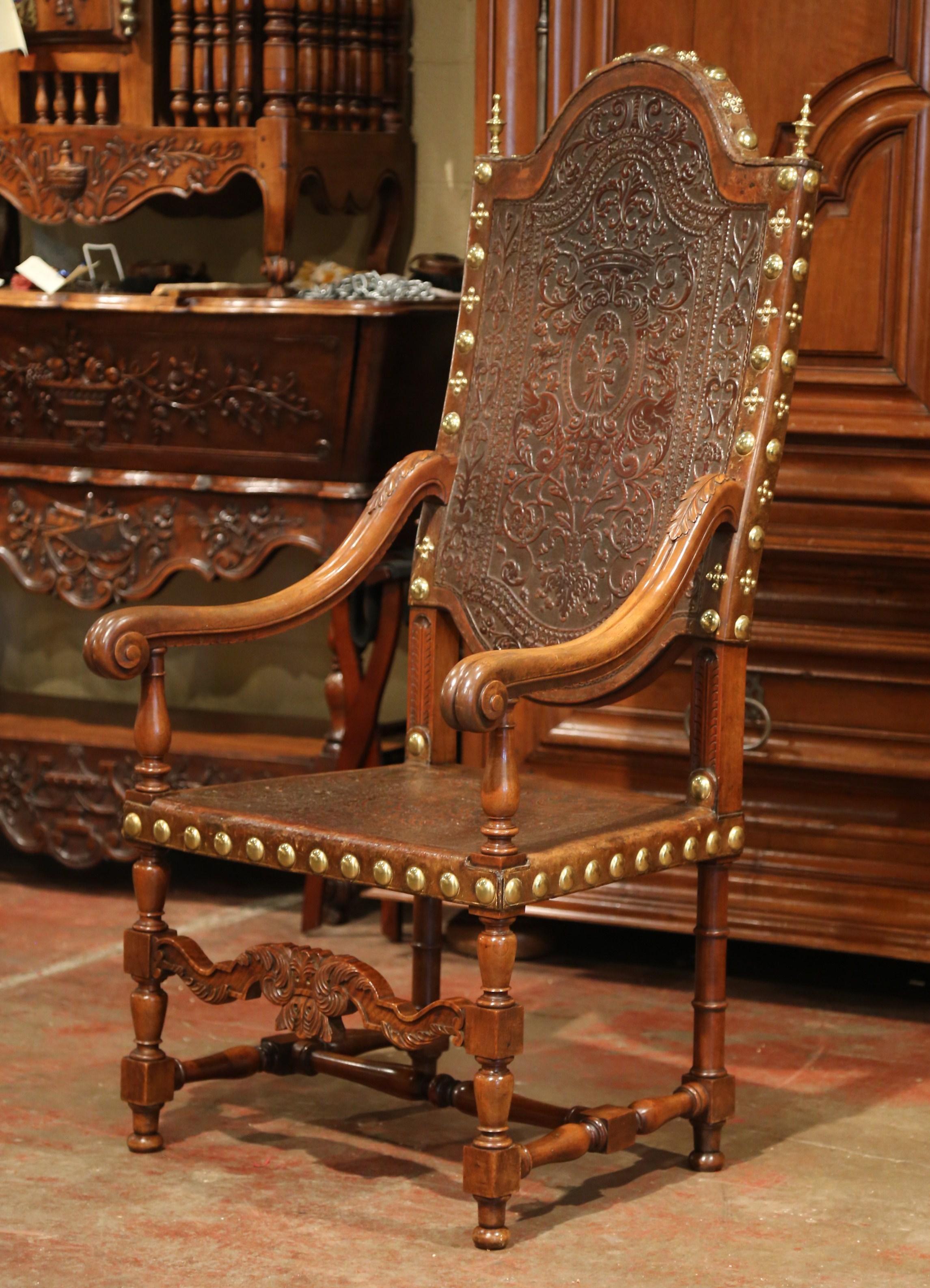 Decorate an office with this Grand, antique fruitwood armchair. Crafted in Spain, circa 1760, the tall stately chair sits on four turned legs with a decorative carved spindle on the facade over a carved front stretcher; the armrests are hand carved