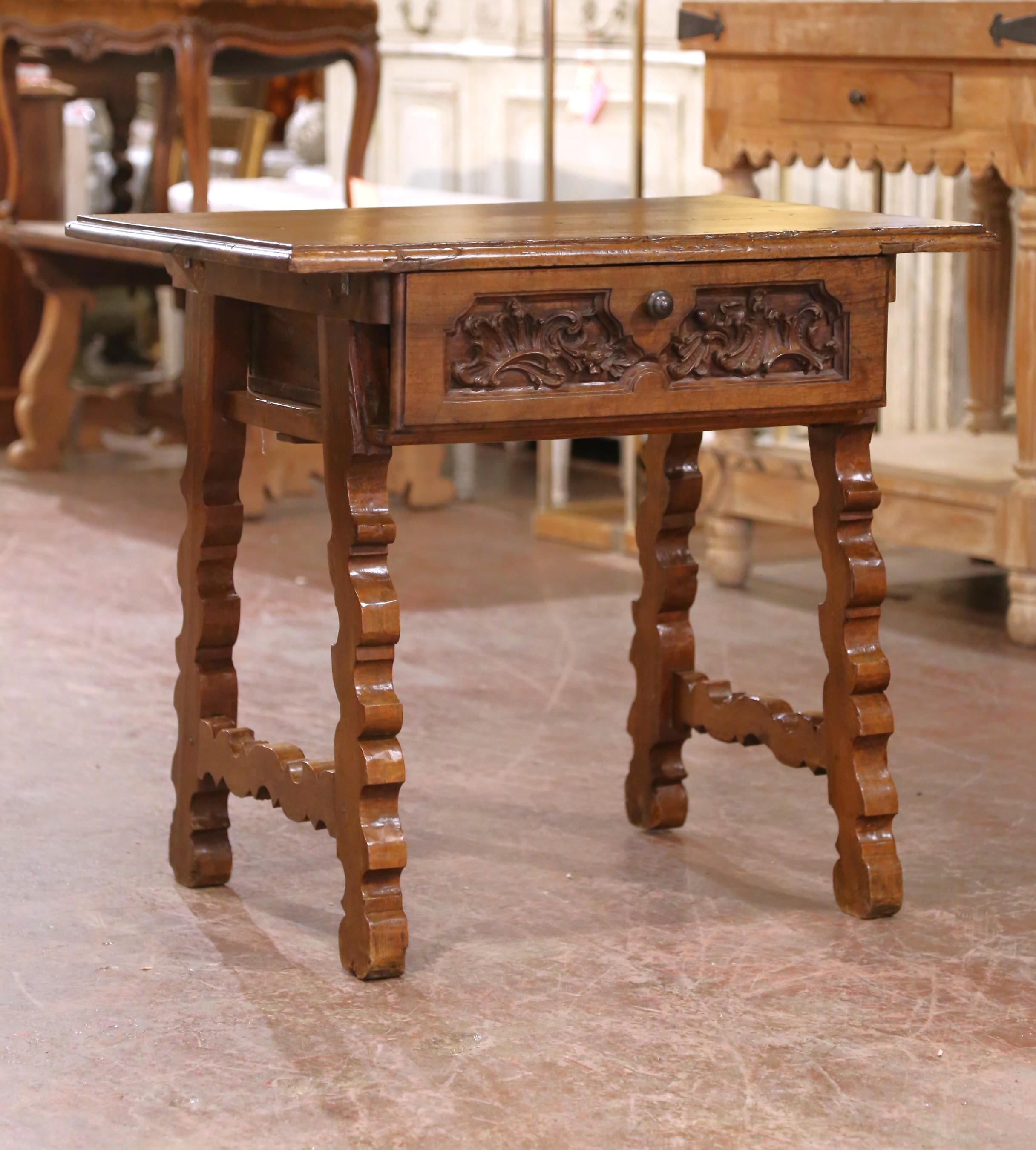 Rustic and sculptural, this 18th-century side table was crafted in the Catalonia region of Spain from solid walnut. The rectangular top, fashioned from a single plank, features molded edges and a deep, hand-rubbed patina that reveals the wood’s