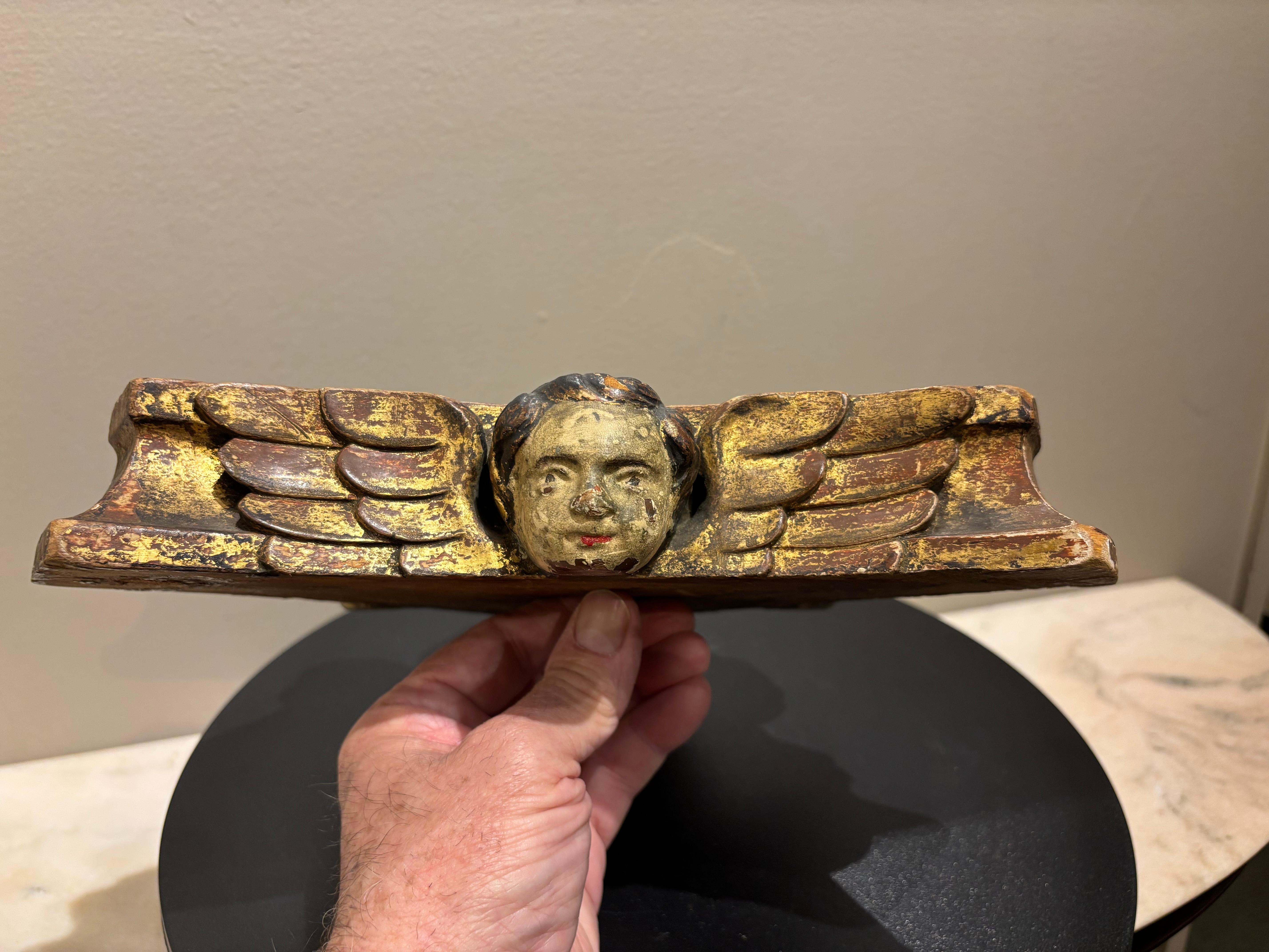 18th century hand carved, painted and gilt triangular wood base with three angel heads with wings. The charming faces of the cherubs are hand painted with black hair and red lips, each with their own individual personality. This unique piece retains