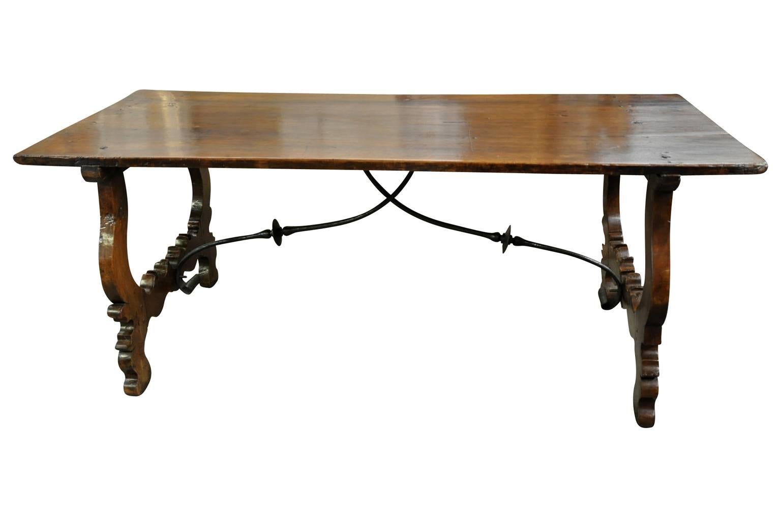 A very beautiful 18th century dining table from Spain. Masterfully constructed from stunning walnut and hand forged iron stretchers, classical lyre shaped legs. Wonderful patina. Terrific not only as a dining table, but will serve beautifully as a