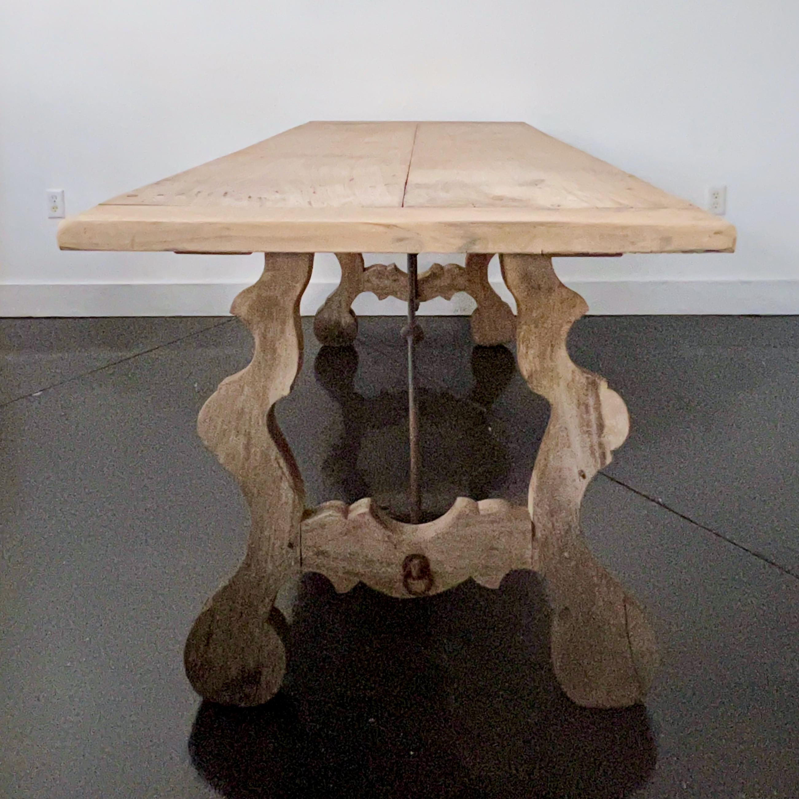 Table de salle à manger espagnole du 18e siècle, superbement patinée, avec une base à tréteaux et des supports en fer forgé, typiques des tables espagnoles. Les pieds ont une forme de lyre classique et soutiennent un plateau en planches