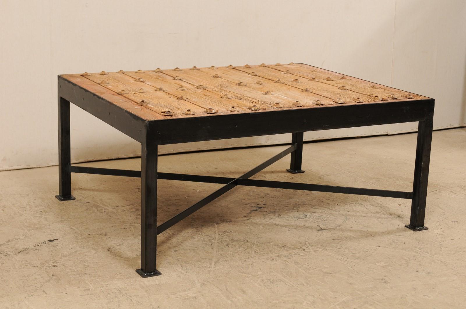 Il s'agit d'une table basse personnalisée fabriquée à partir d'une porte espagnole du 18e siècle. Cette merveilleuse table basse a été façonnée à partir d'une porte espagnole du XVIIIe siècle, avec un plateau en planches de bois, à la patine