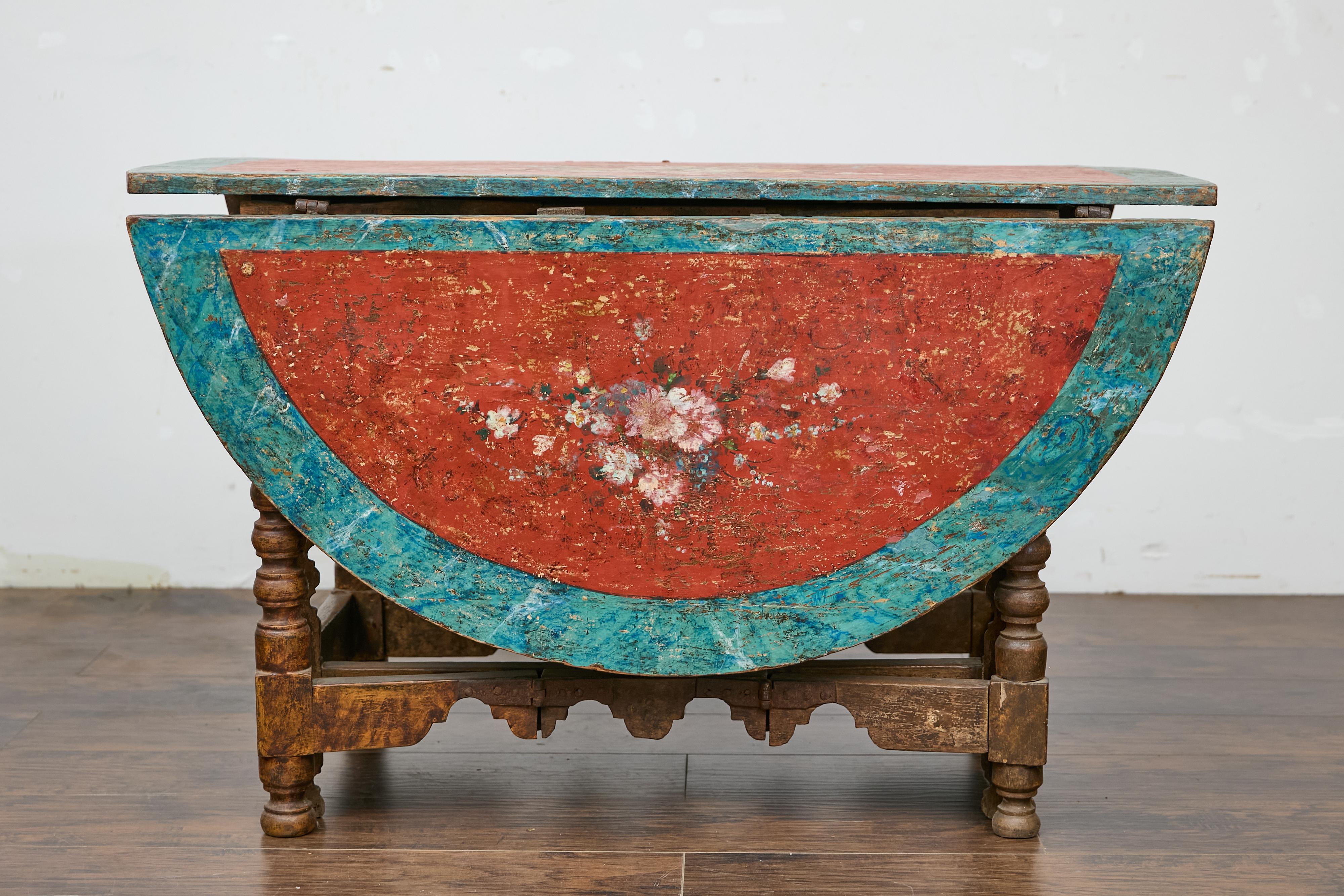 A Spanish gateleg drop leaf table from the 18th century with original painted floral polychrome décor. This 18th-century Spanish gateleg drop leaf table enchants with its original painted floral polychrome décor, bringing a touch of history and