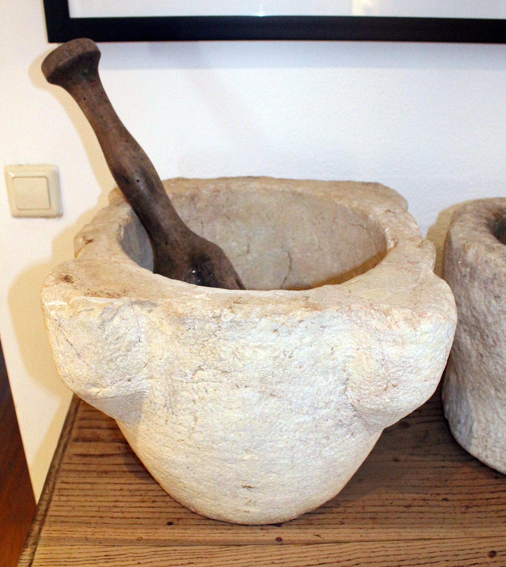 18th century Spanish hand carved stone kitchen mortar and wooden pestle, used in kitchens and pharmacies to prepare herbs for cooking or healing.
 