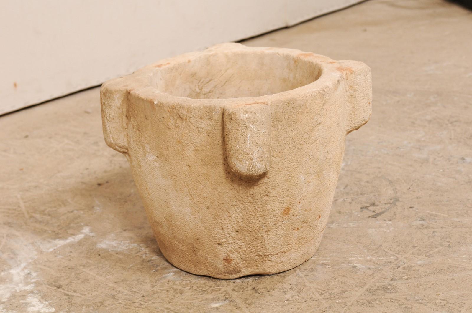 A Spanish hand carved stone mortar from the 18th century. This antique mortar from Spain, once used to grind various ingredients for cooking or medicinal purposes, is nicely sized standing at 14
