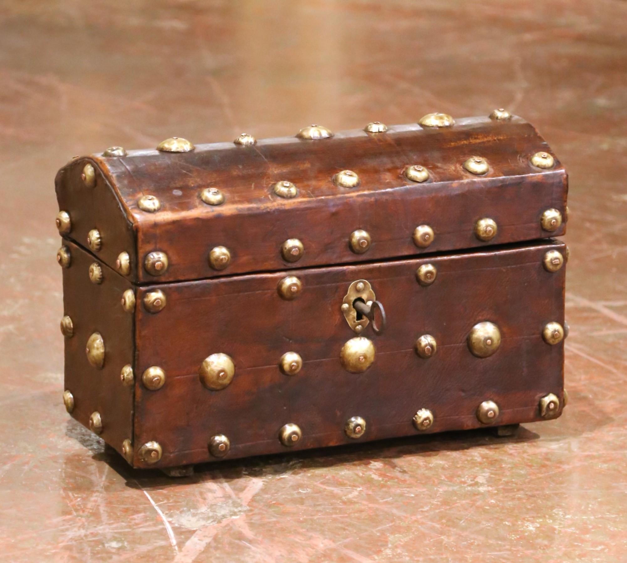 This handsome Spanish trunk was crafted circa 1780 and features a domed wooden frame clad in hand-stitched leather, richly decorated with large and small brass nailheads in a rhythmic, geometric pattern. The ornamentation reflects the cuero