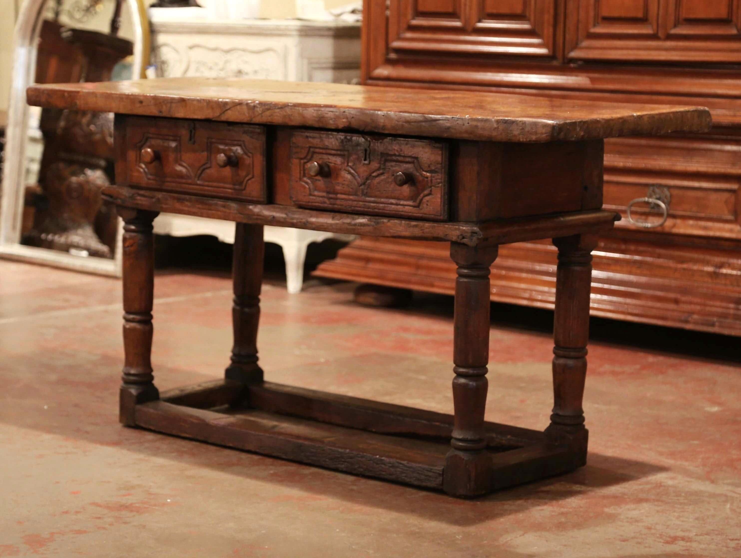 This elegant antique fruitwood console was crafted in Spain, circa 1760. The sofa table stands on four turned legs decorated with a rectangular stretcher at the base; it features a pair of drawers across the front with carved geometric decor and