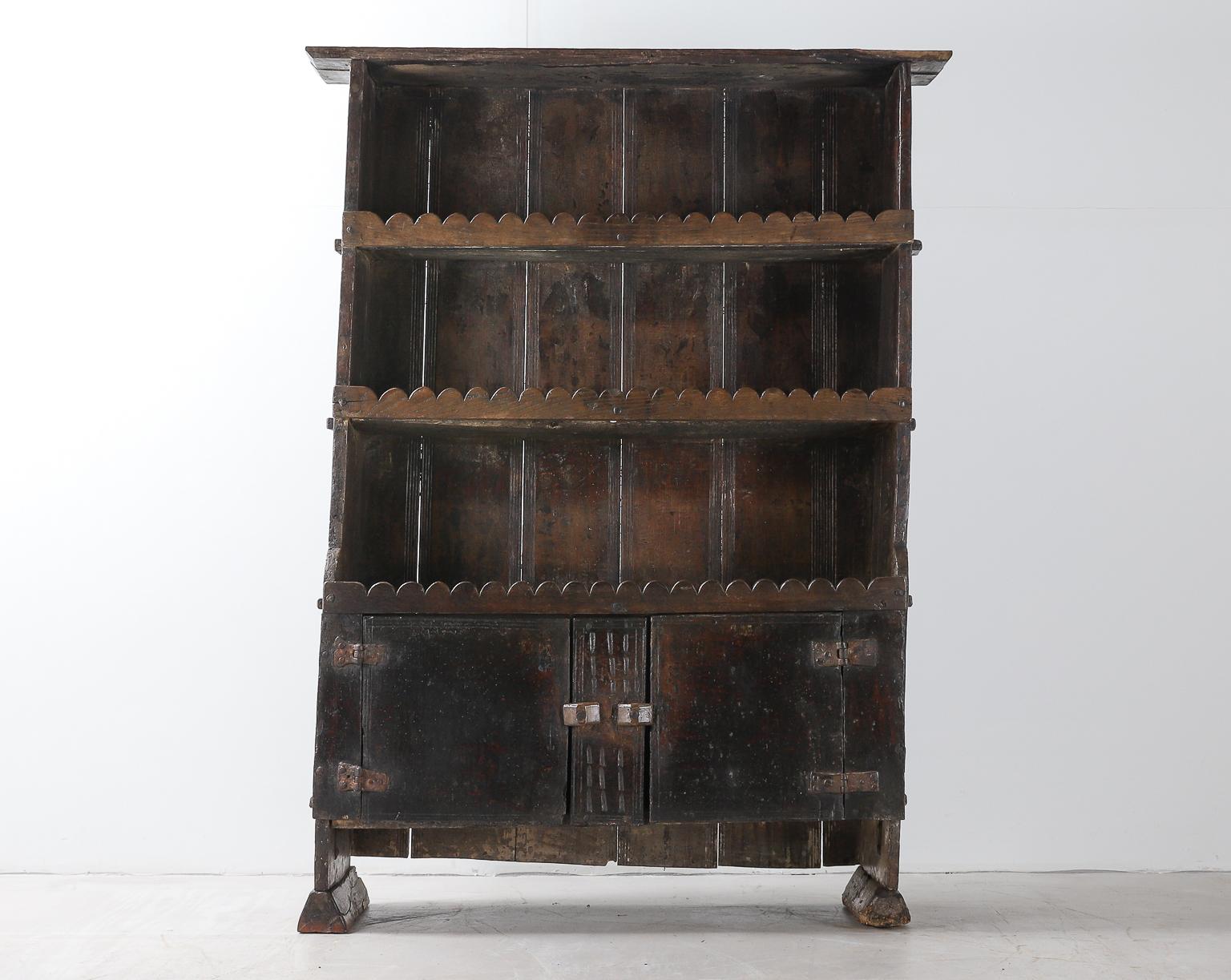18th Century Spanish open oak dresser with hand carved plank backboard, scallop shelf fronts and two cabinet doors below which allow more discreet storage.

Recently restored, the piece is in good condition consistent with age and structurally