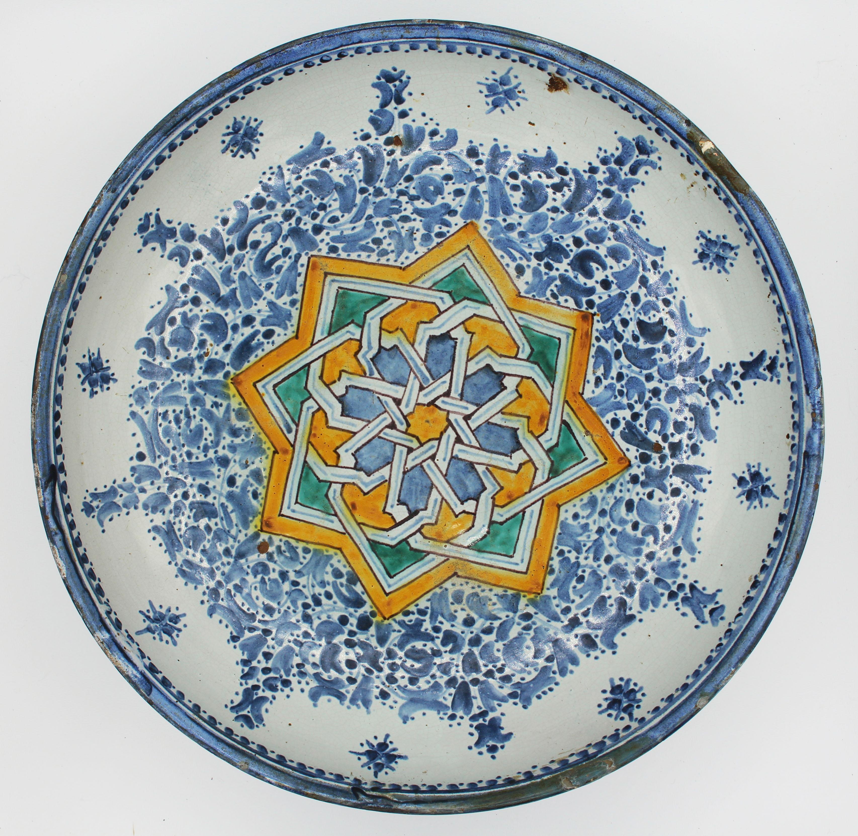 A stunning Spanish or North African faience deep bowl. 18th century. Well cared for with various old rim repairs typical of the form. Red ware base. 15 1/4