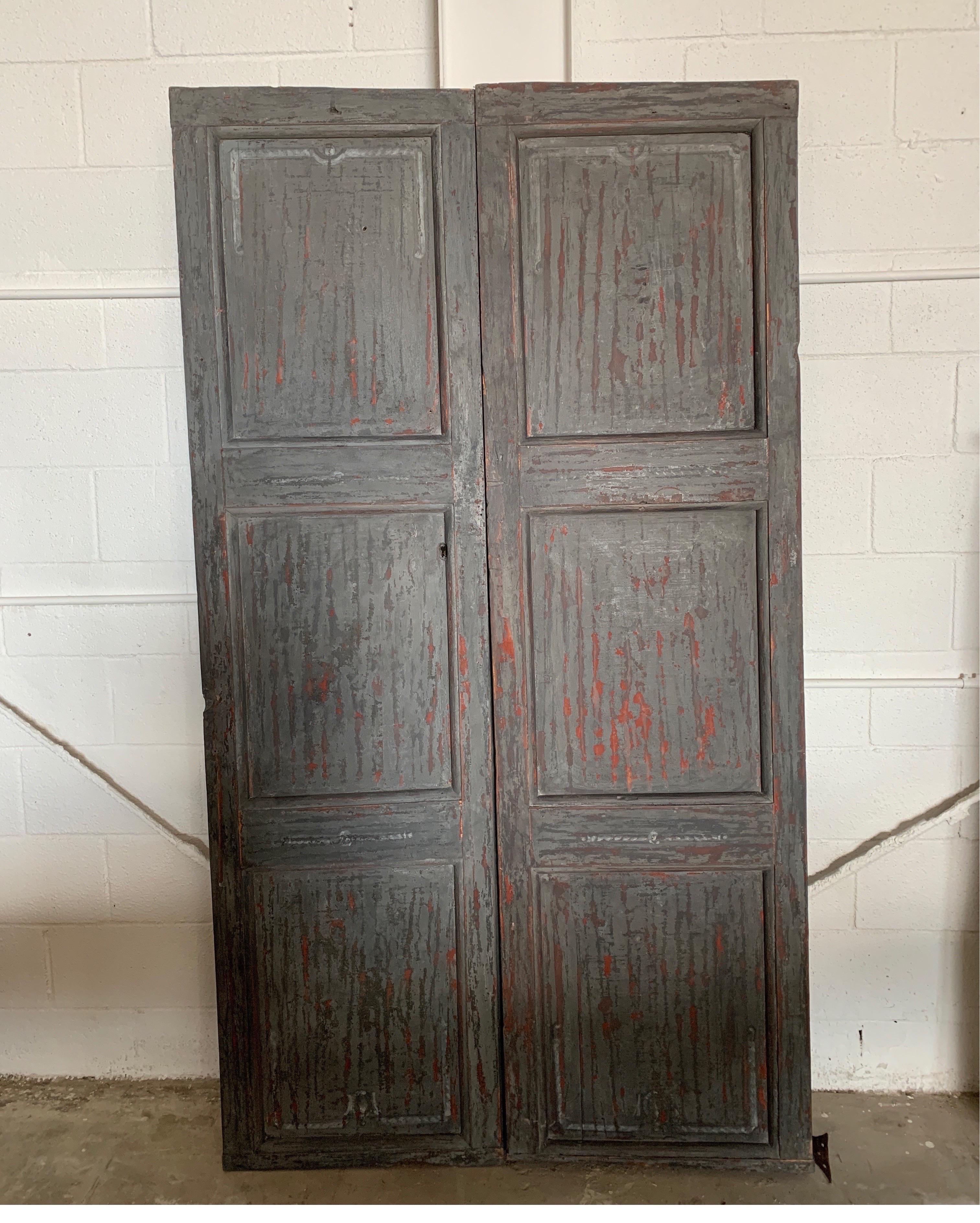 These rustic doors from the 1700s in Spain are a beautiful color of gray, black and rust. They have the original hardware and are nicely painted with detail on front. The backs are just as nice where the hardware shows.