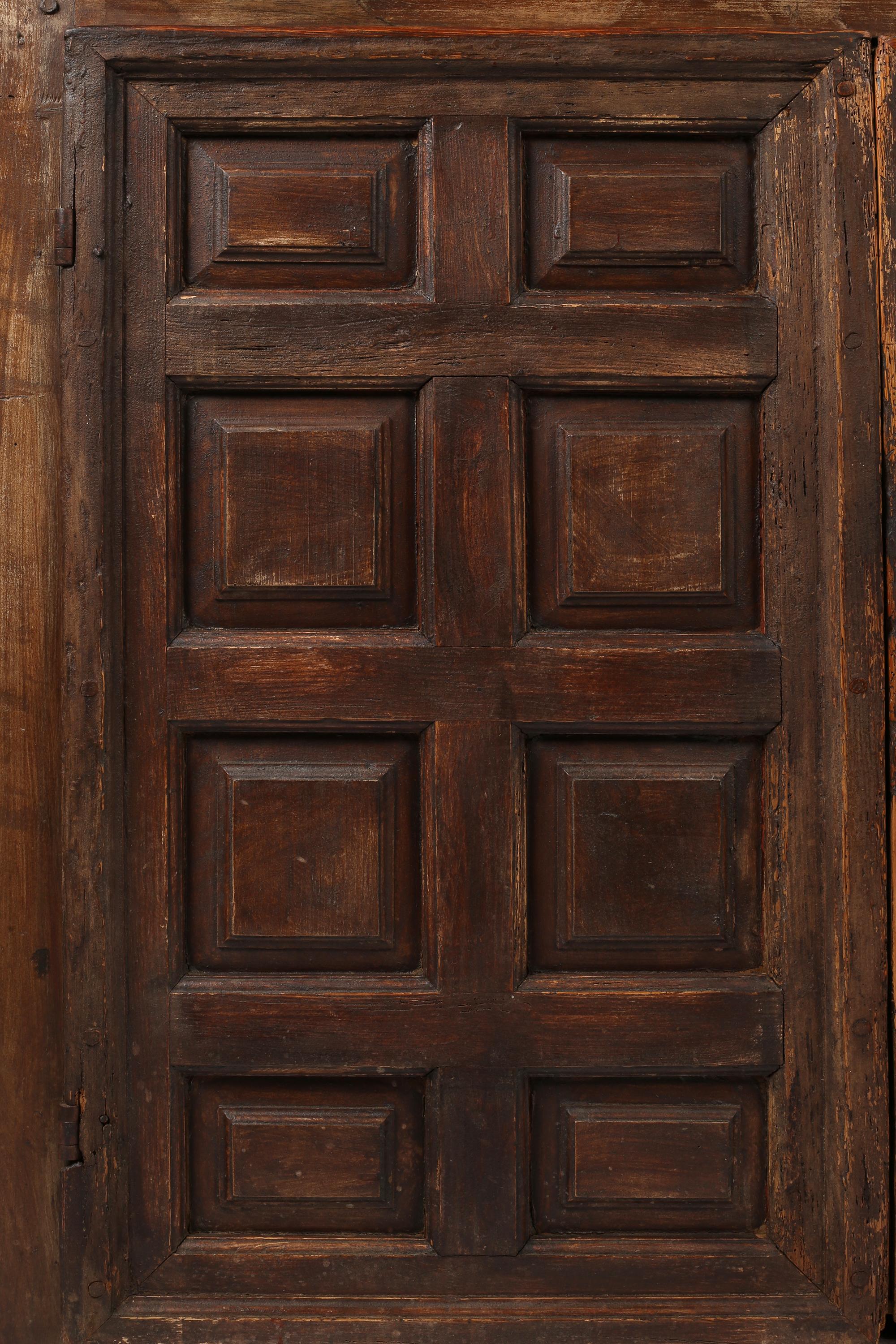 A satisfyingly geometric 18th century cupboard constructed from a combination of oak, beech and pitch pine timbers. With strong proportions and a rich patina, featuring two grid panelled doors which open to reveal four shelves within. Original