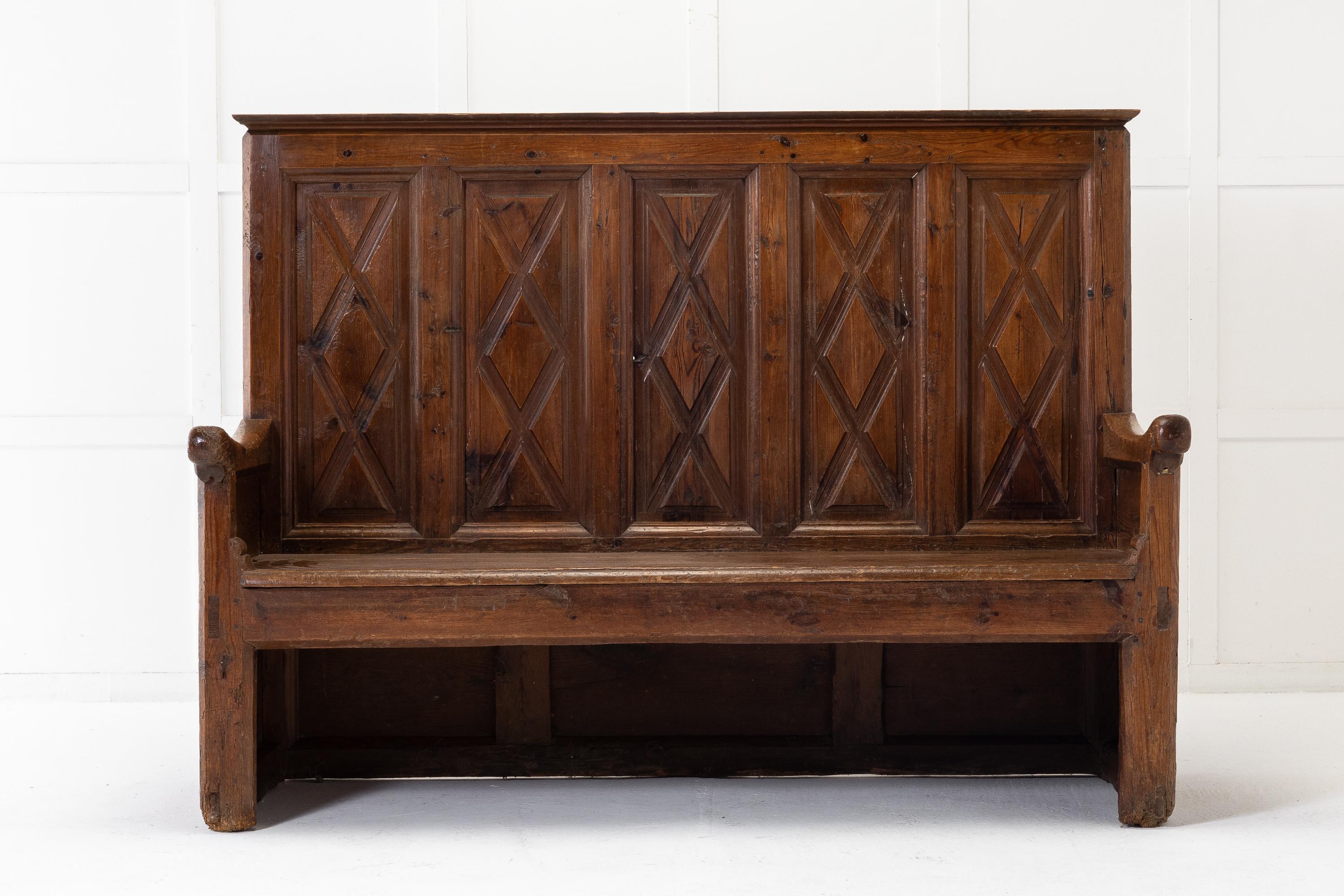 18th Century Spanish pine rustic bench with a high back topped with a moulded cornice. Five fielded panels are decorated with geometrical diamond shapes, the patterns continue to the sides and are similar on the back with lower three panels to the