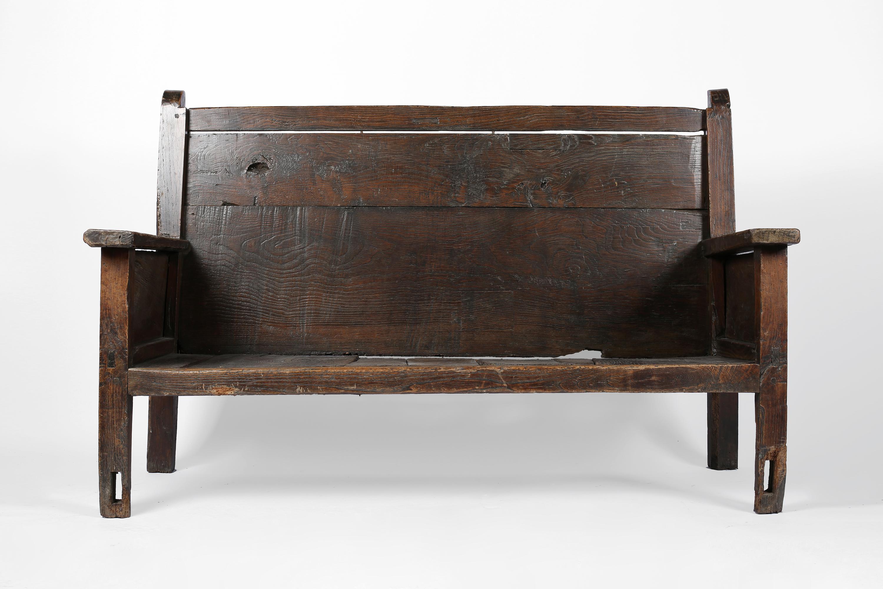 A large late 18th century bench from the Pyrenees Mountains in northern Aragon. Primitively constructed from dark, heavily patinated pine timber - a one-off piece, likely built for a rural estate. Spanish, c. 1780.