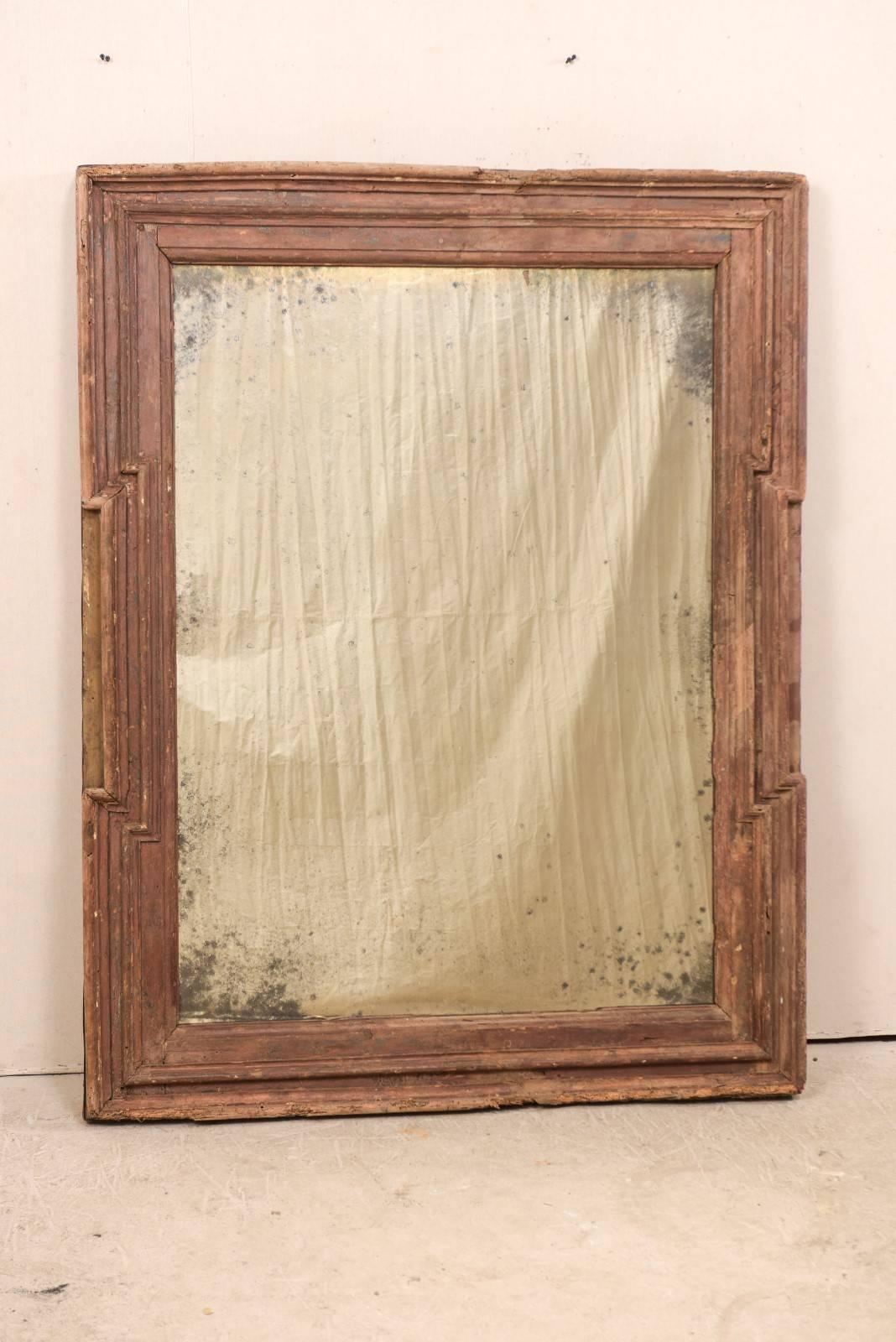 A Spanish 18th century wood rectangular-shaped mirror. This antique mirror from Spain, with it's rectangular shape, has a molded surround with step-in details flanking the trim at either side, and newer, antiqued mirror recessed within it's center.