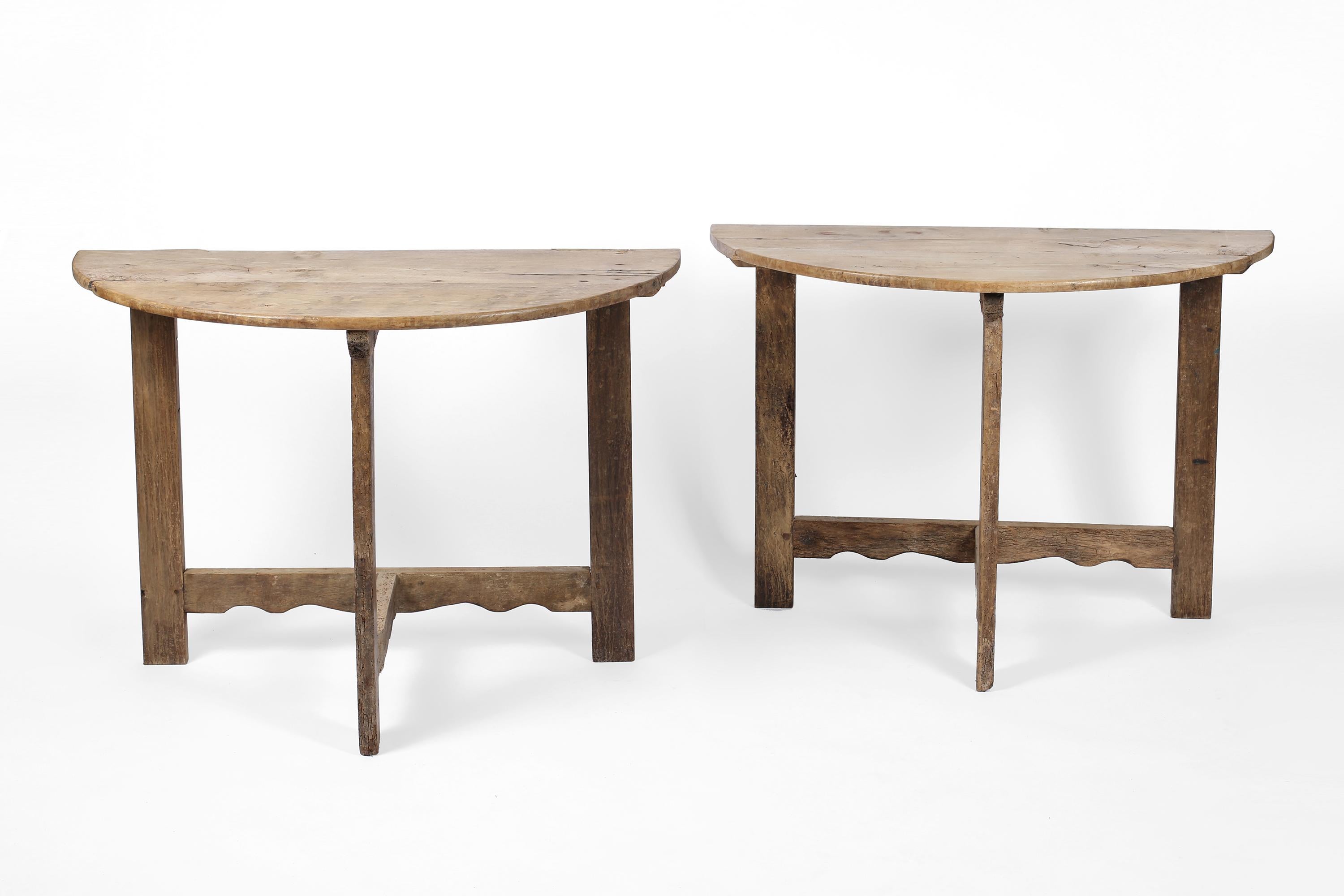 Sold separately. 

A pair of characterful late 18th/early 19th century demi-lune console tables with bleached walnut tops and serpentine detailing to their stretchers. Likely once a single table, the pair can be arranged to create a circular centre